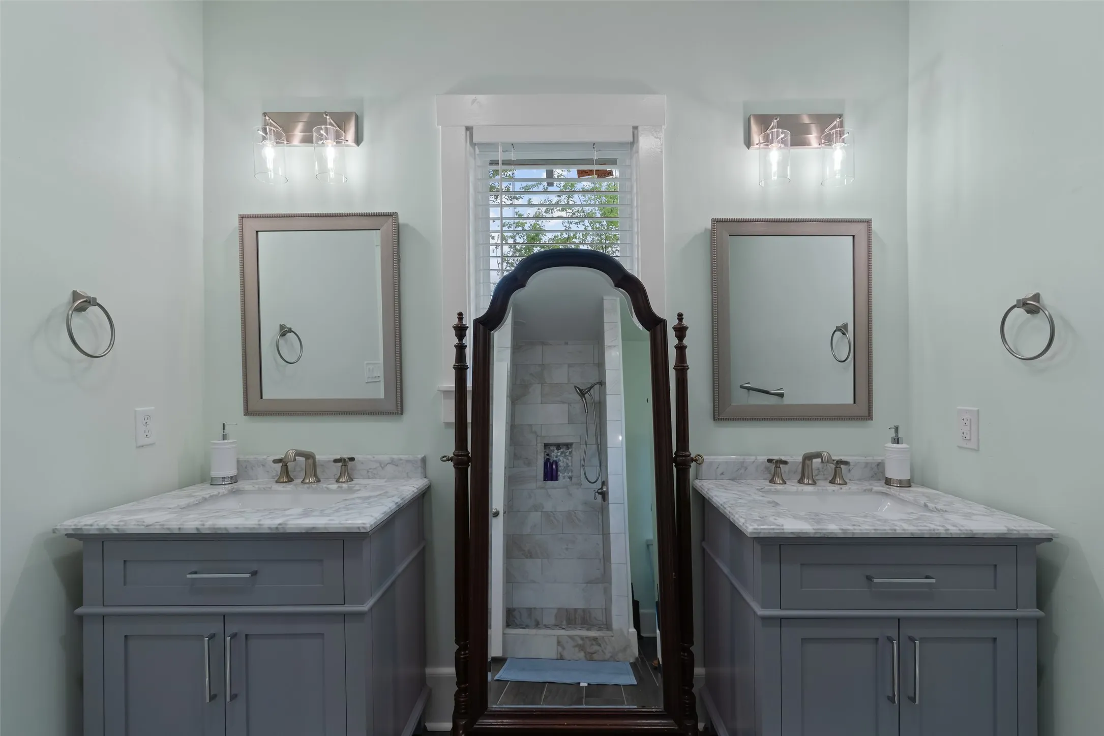 Primary bathroom with dual vanities & walk-in shower.