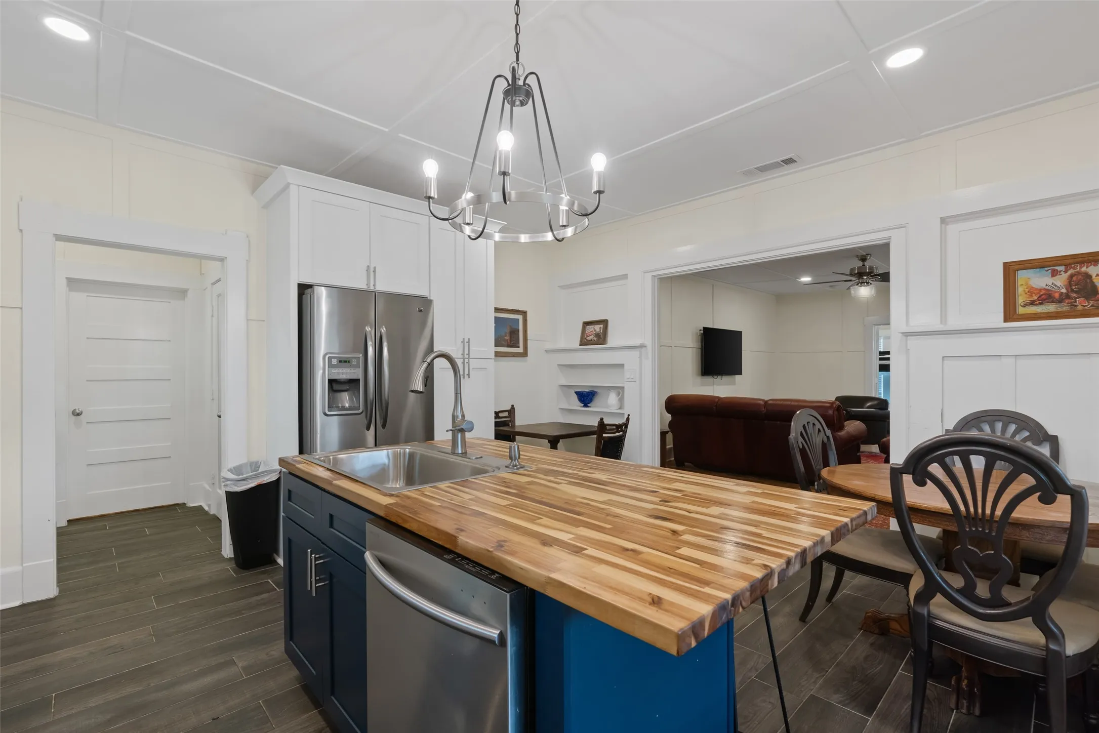 Navy kitchen island with butcher block countertop & open dining area.