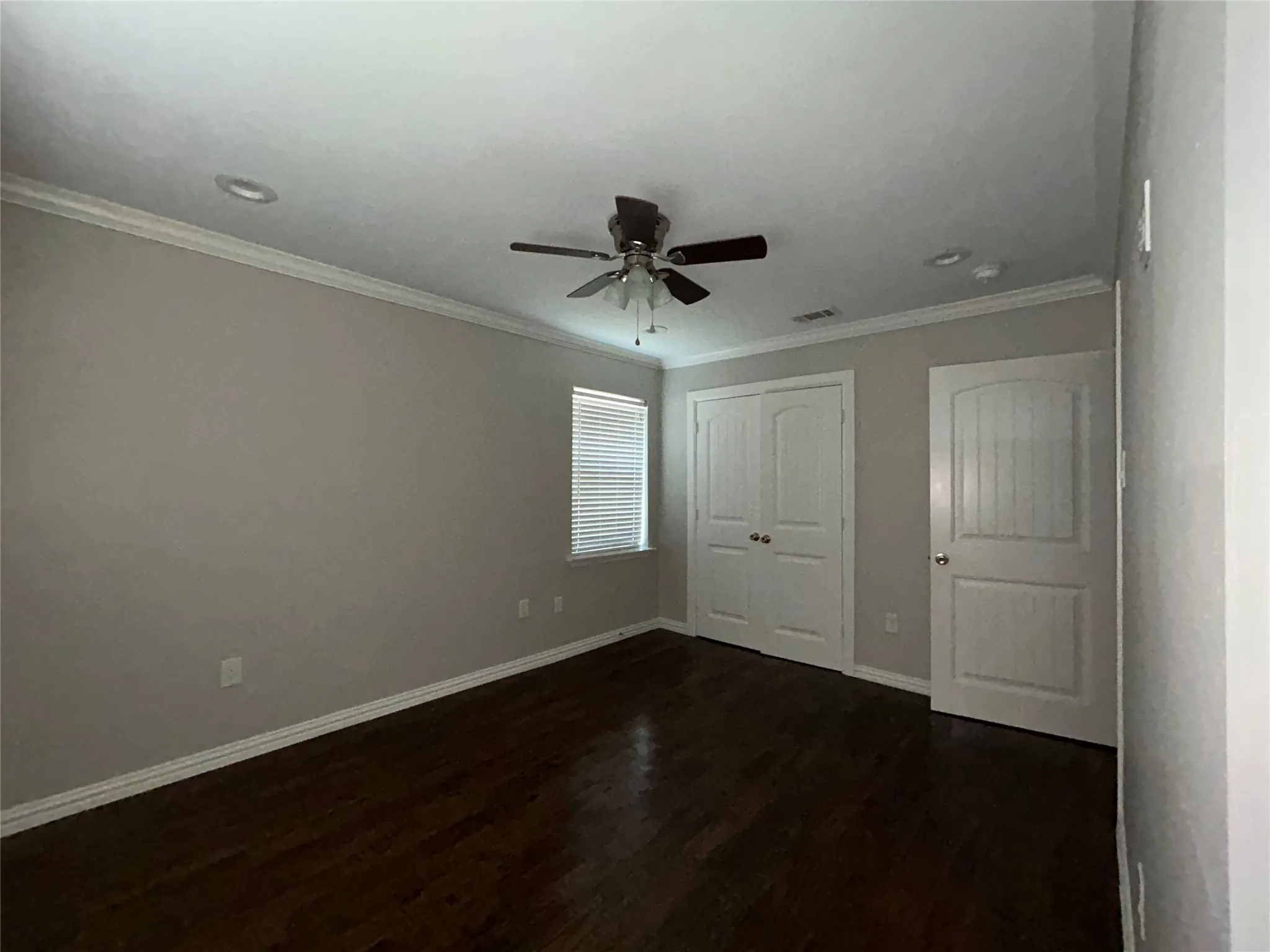 Dark wood-finish flooring, ceiling fan with integrated lighting, recessed lighting, white window blinds, and white trim throughout