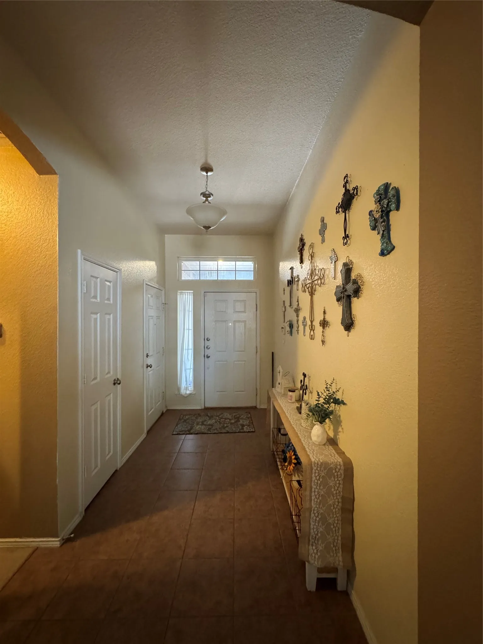 Entryway featuring a white paneled door, transom window, and tile flooring