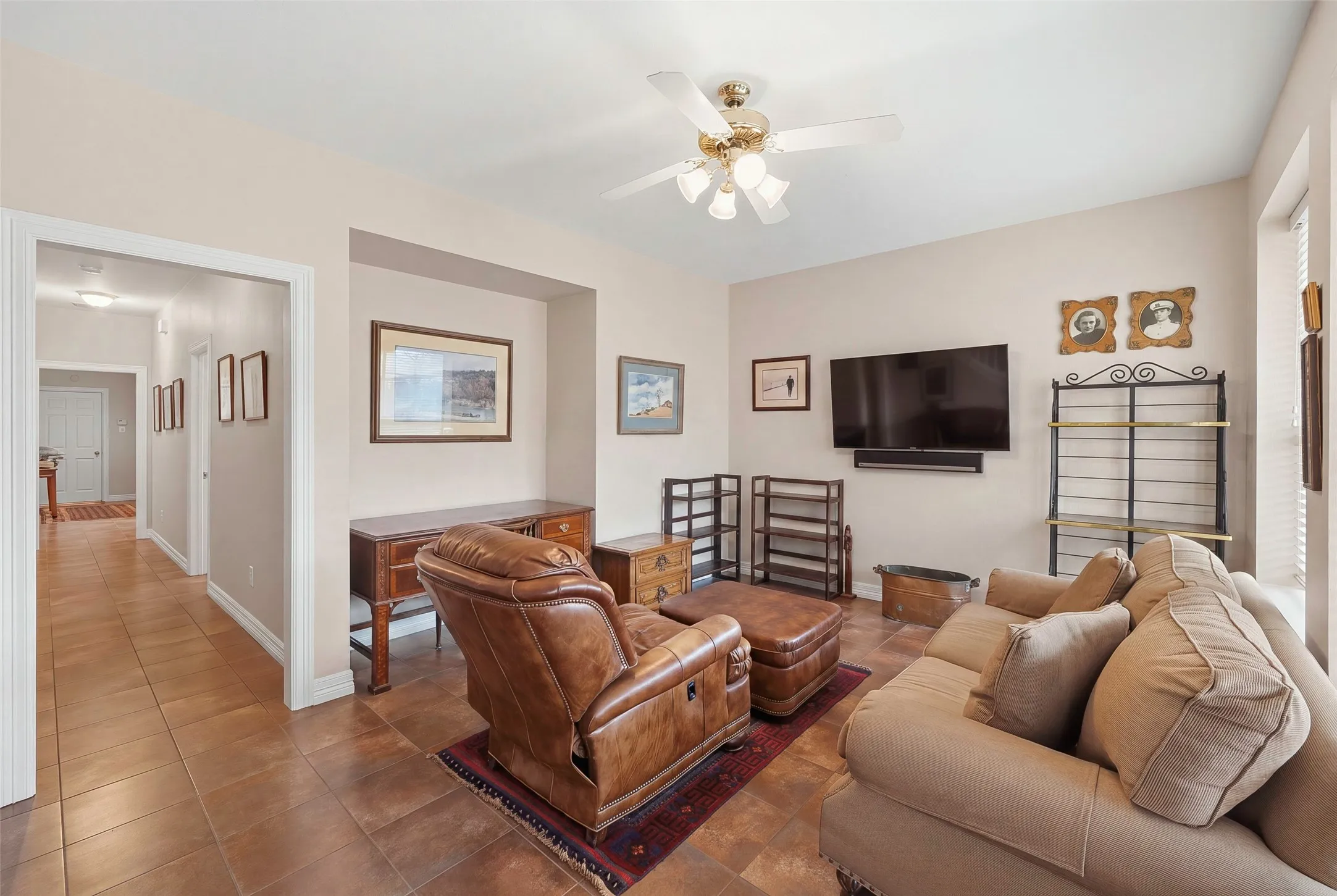 Recessed wall niche, ceiling fan with light fixture, tile flooring, and neutral wall tones