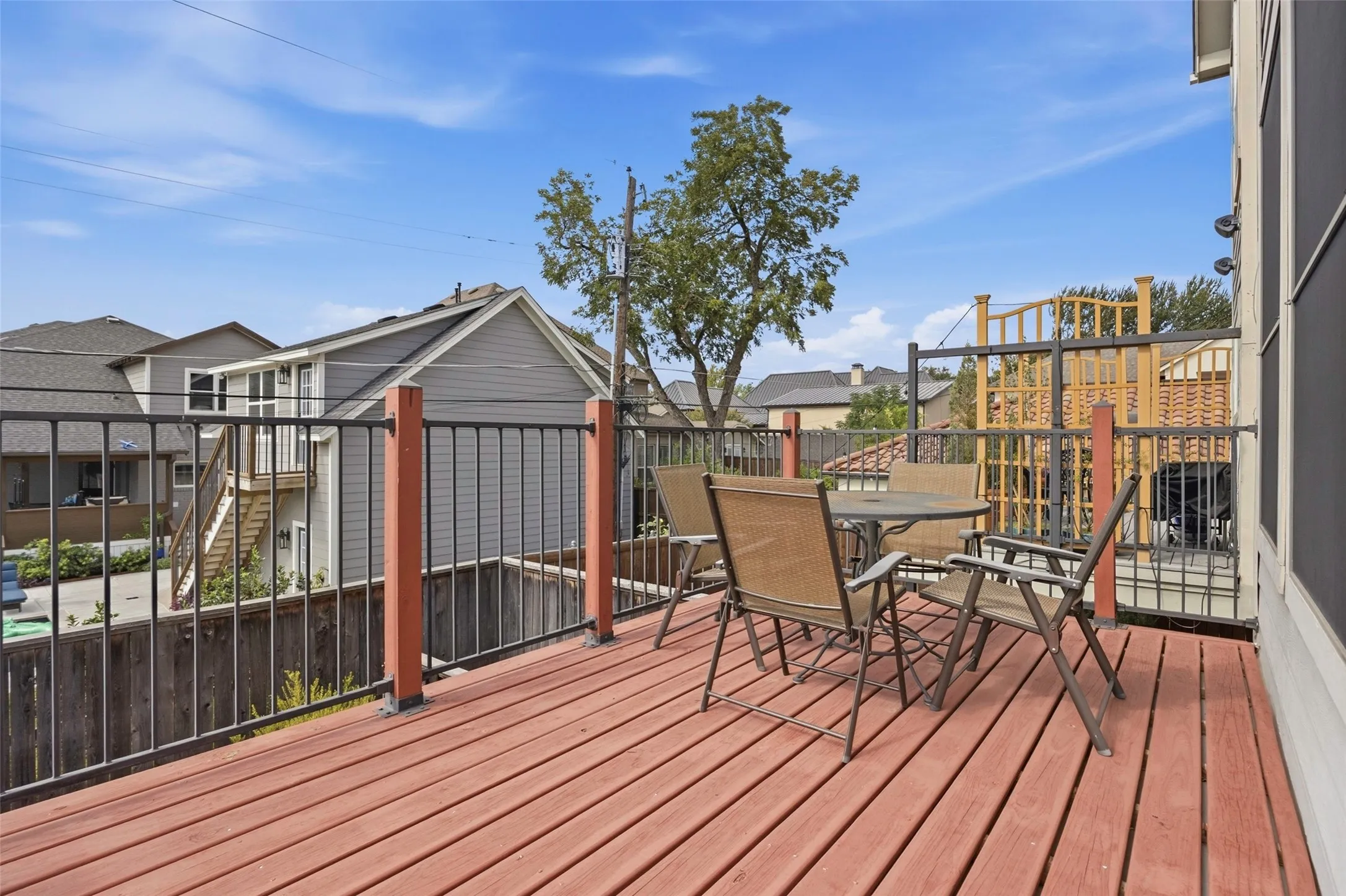 Expansive wood-finish decking with a black metal railing