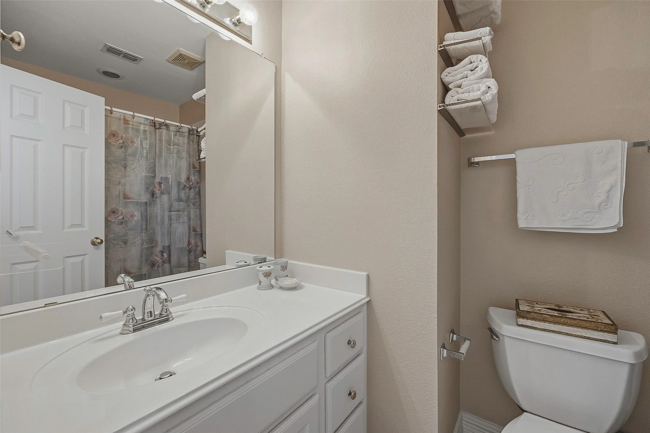 Vanity with integrated sink, chrome faucet, and white cabinetry