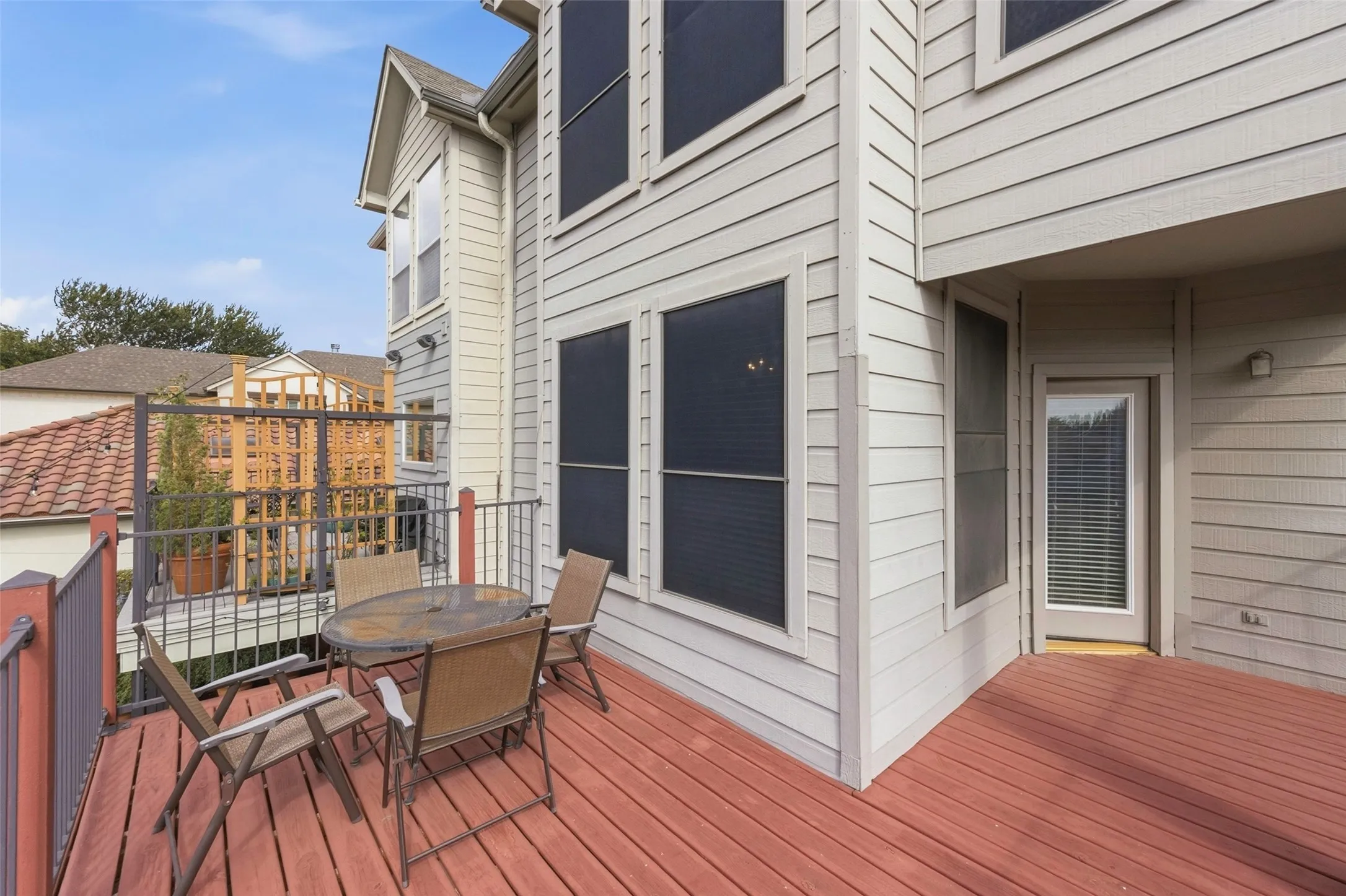 Expansive wood-finish deck with metal railings and direct outdoor access