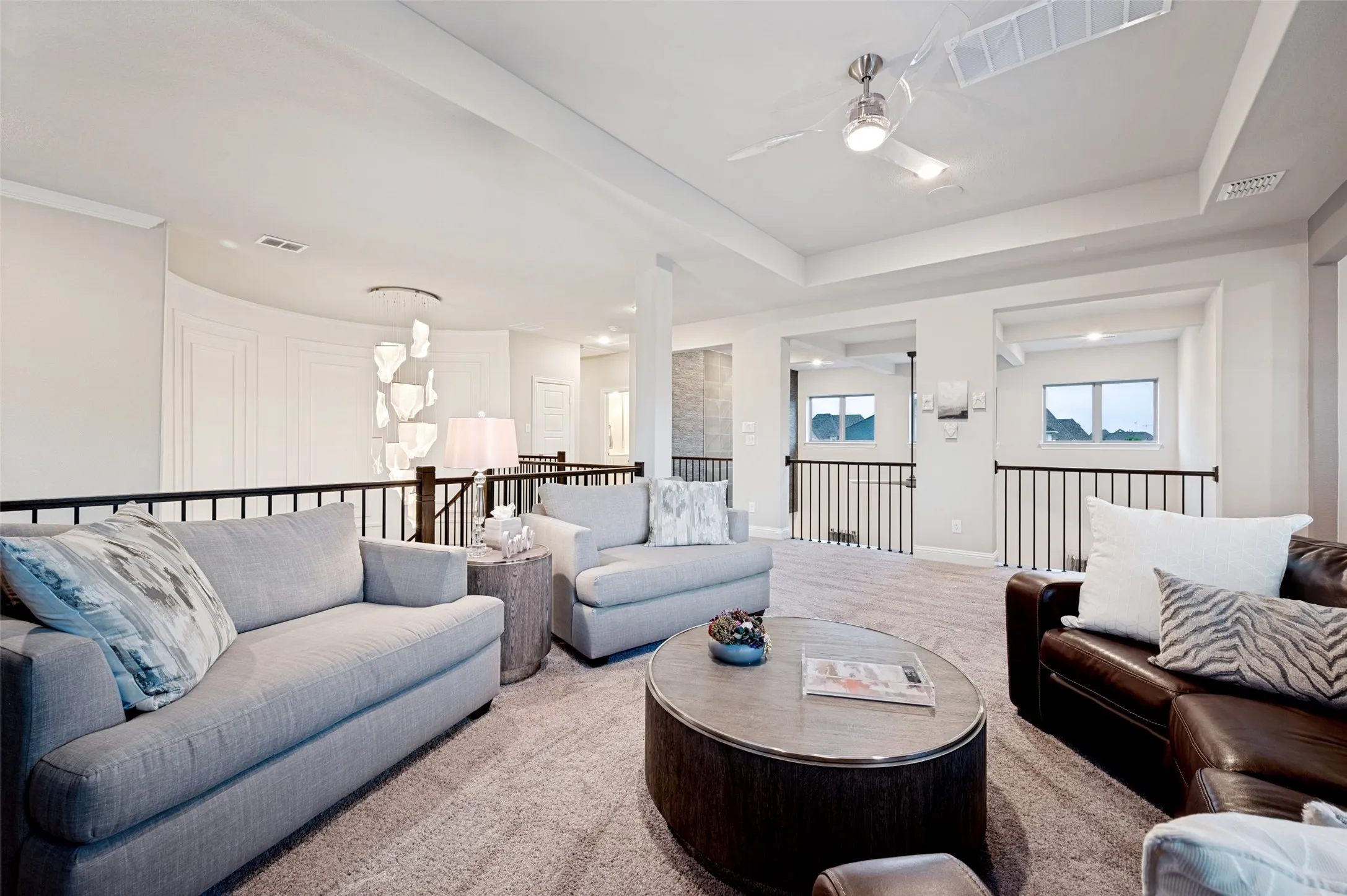 Spacious loft area with tray ceiling, ceiling fan, and wrought iron​​‌​​​​‌​​‌‌​‌‌​​​‌‌​‌​‌​‌​​​‌​​ railings