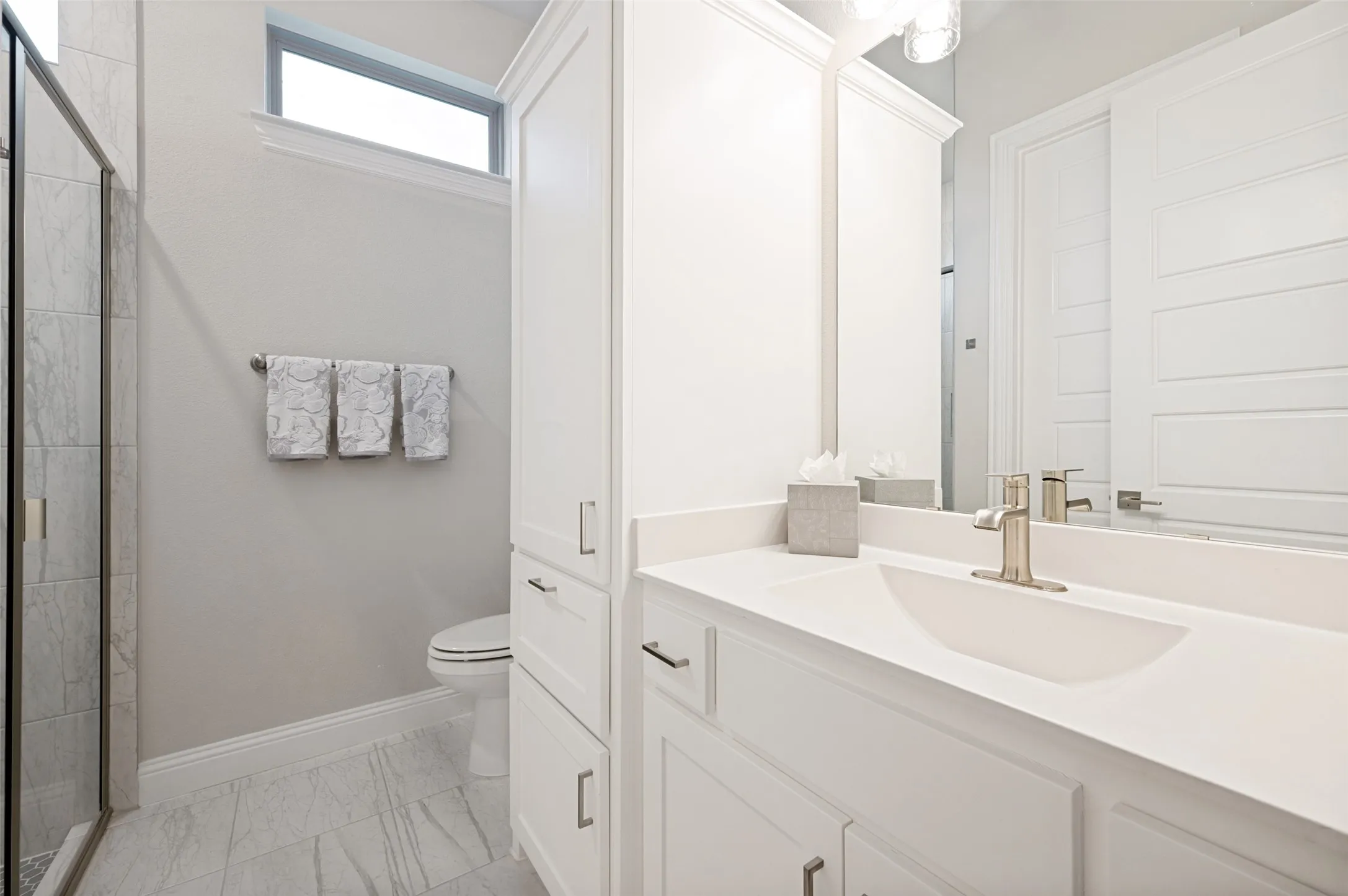 Spa-inspired bathroom featuring a dual-sink vanity with white cabinetry, quartz countertop, and chrome fixtures