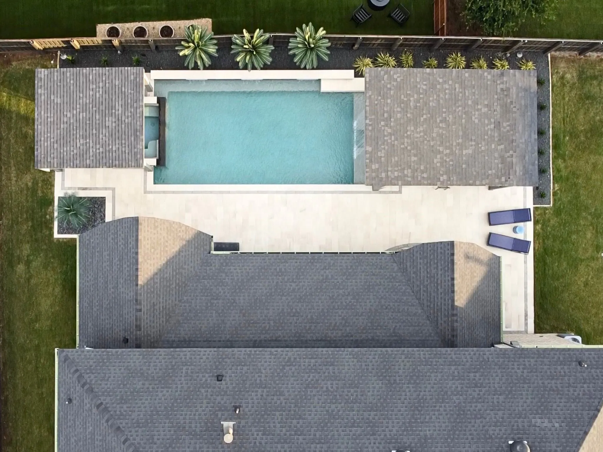 Expansive backyard featuring a rectangular swimming pool, integrated spa, and extensive paver patio