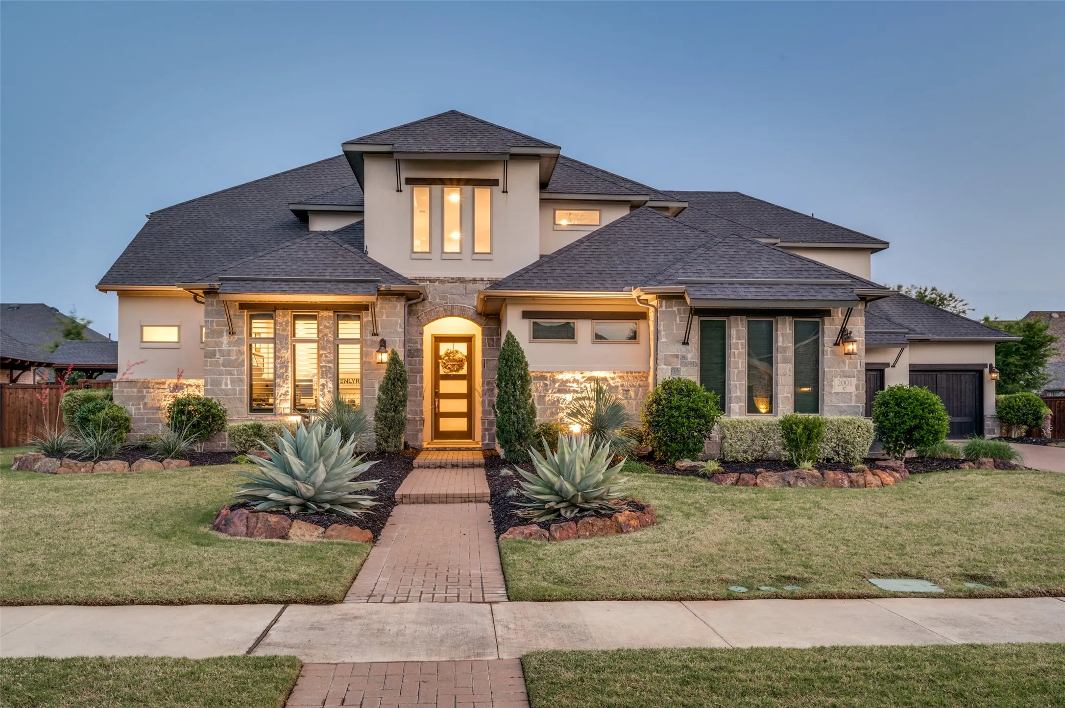 Stucco and stone exterior with dark shingles