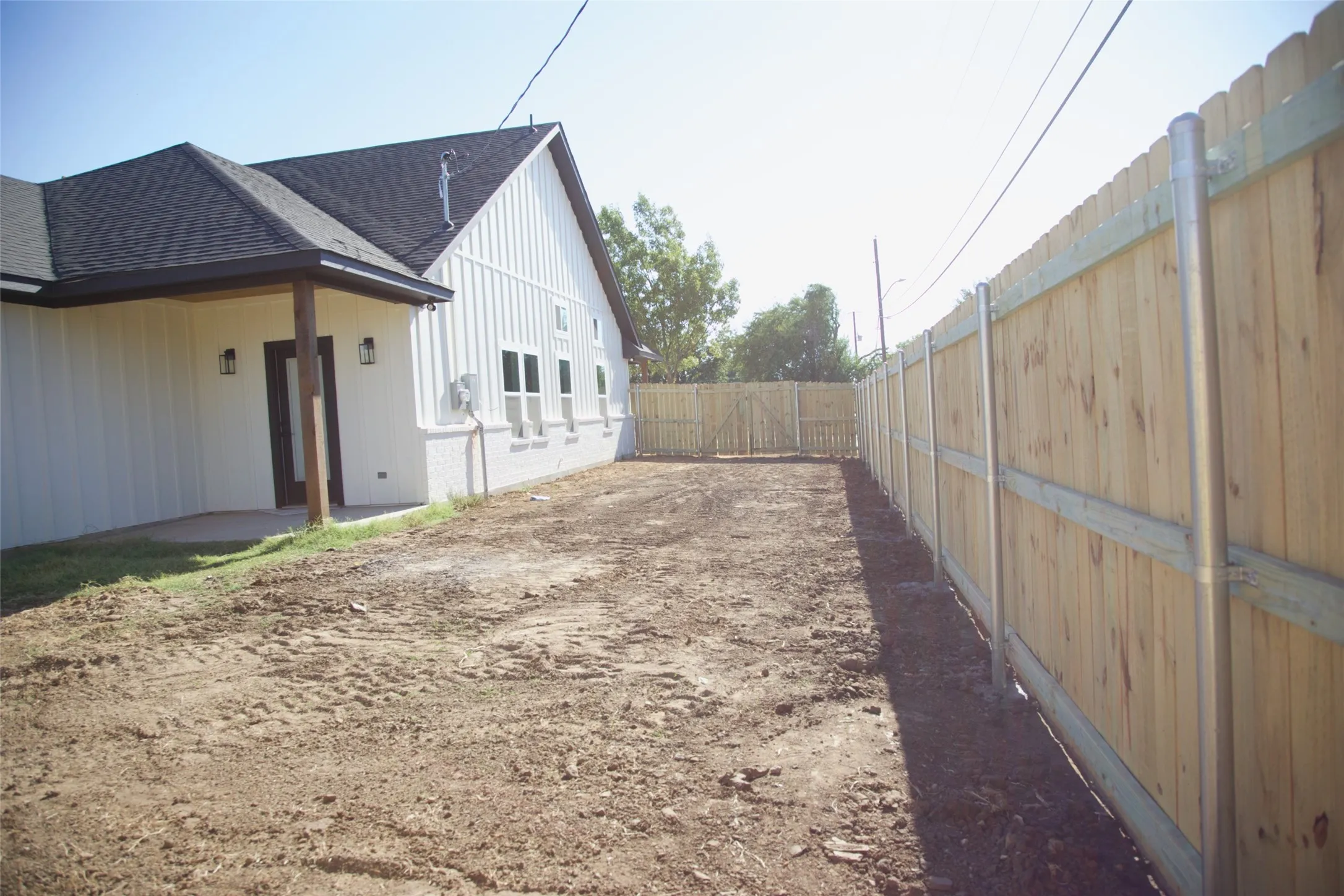 White board-and-batten siding with a dark asphalt shingle roof