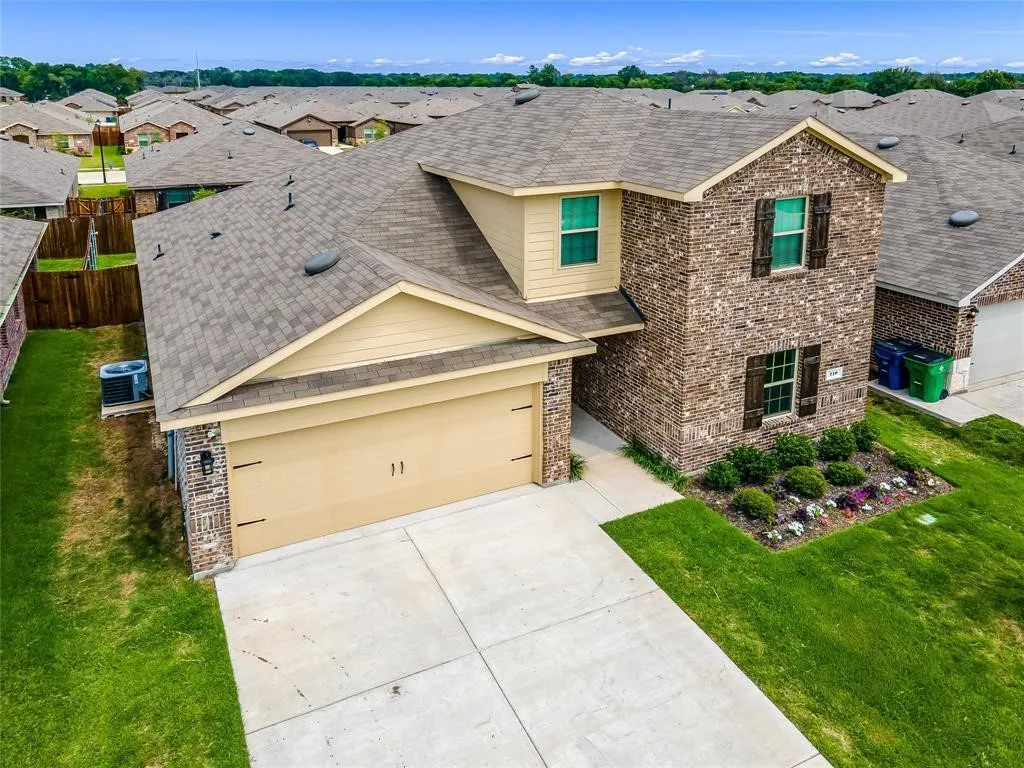 View of front of house featuring a garage, a front lawn, and central AC unit