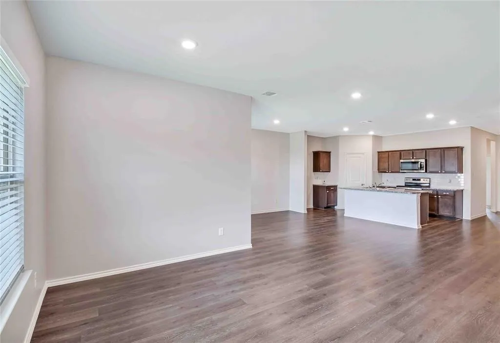 Unfurnished living room with dark wood-type flooring
