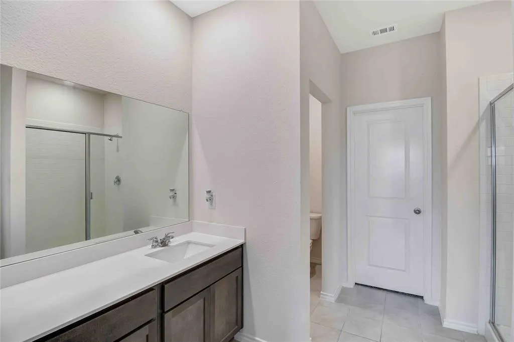 Bathroom with vanity, toilet, and walk in shower