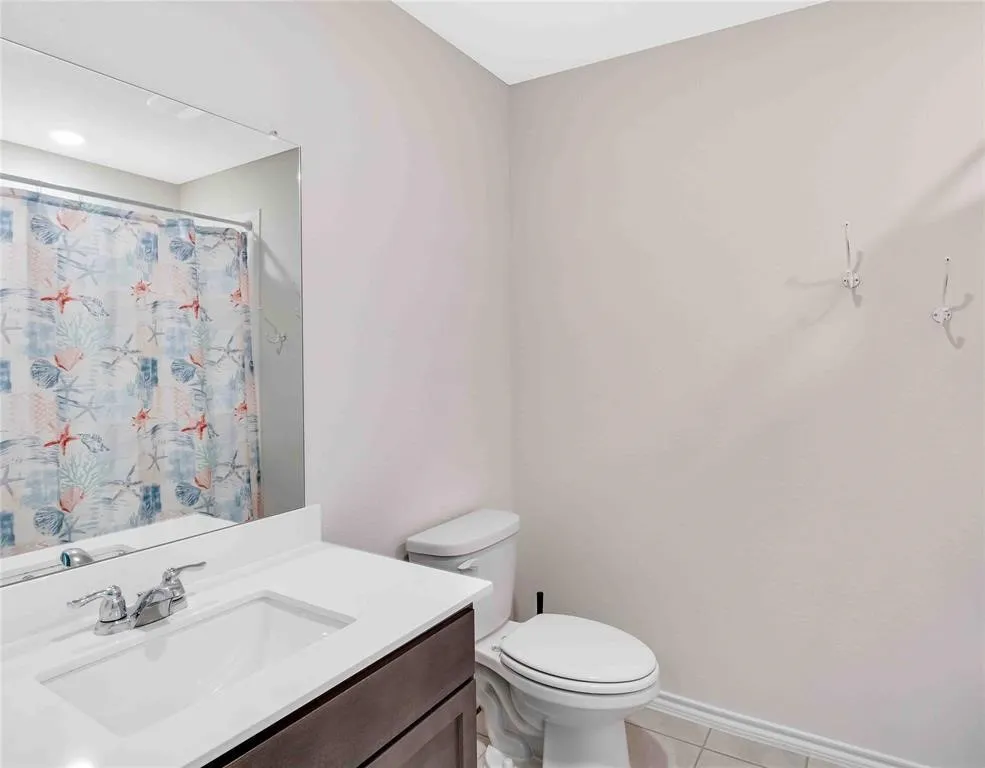 Bathroom with vanity, toilet, and tile patterned floors