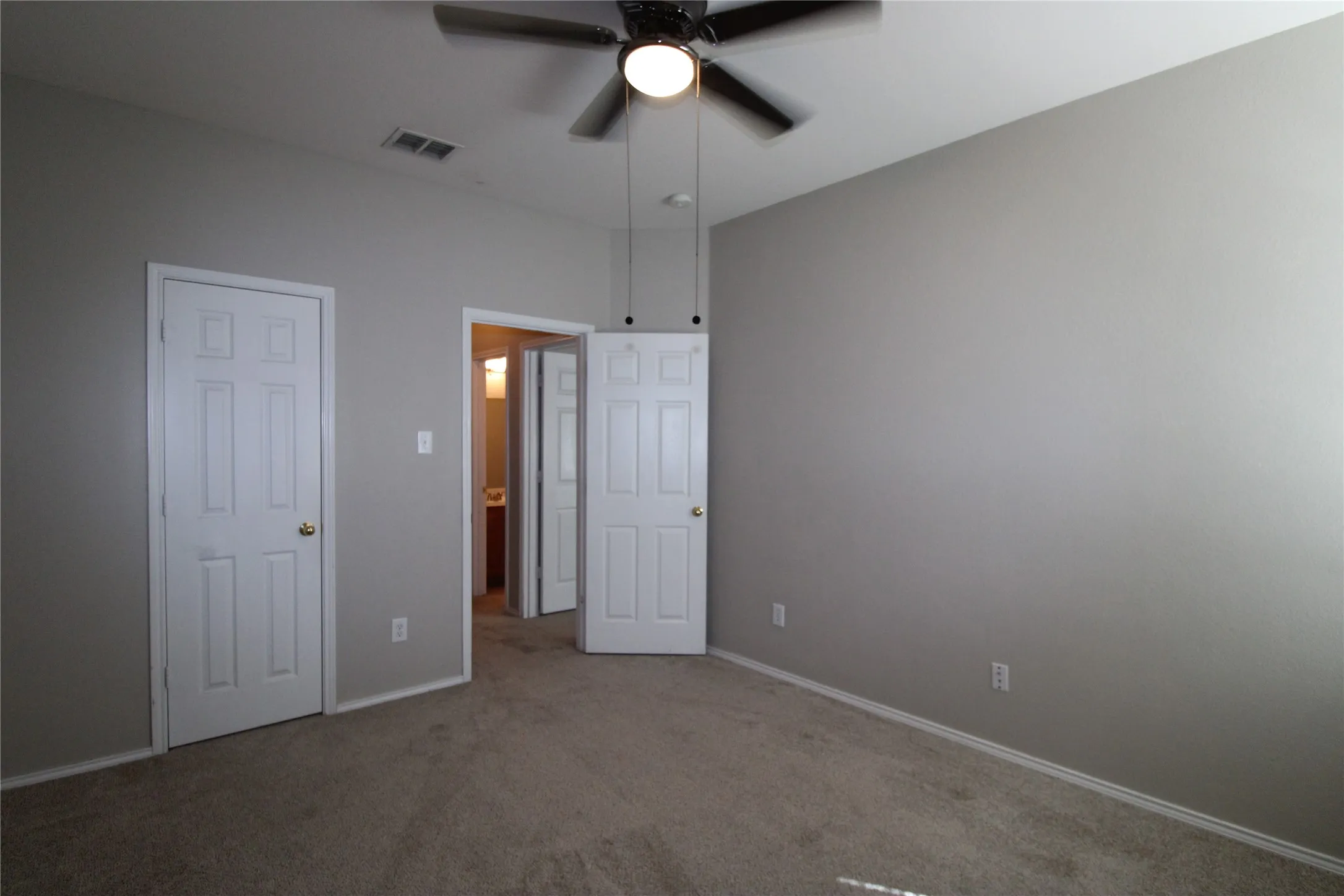 Carpeted room with a ceiling fan, light gray wall paint, and white trim