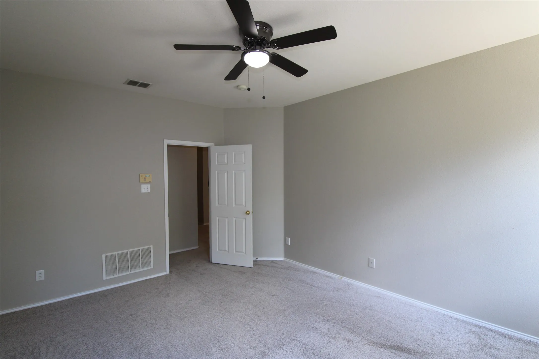 Neutral wall paint, ceiling fan with integrated lighting, and carpet flooring