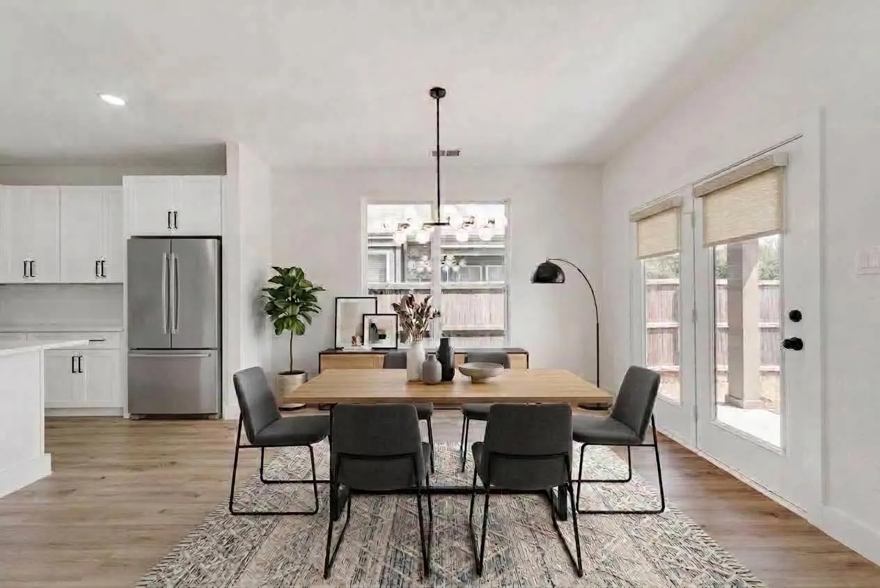 Open-concept dining area with wood-finish flooring, a contemporary chandelier, and direct access to an outdoor patio