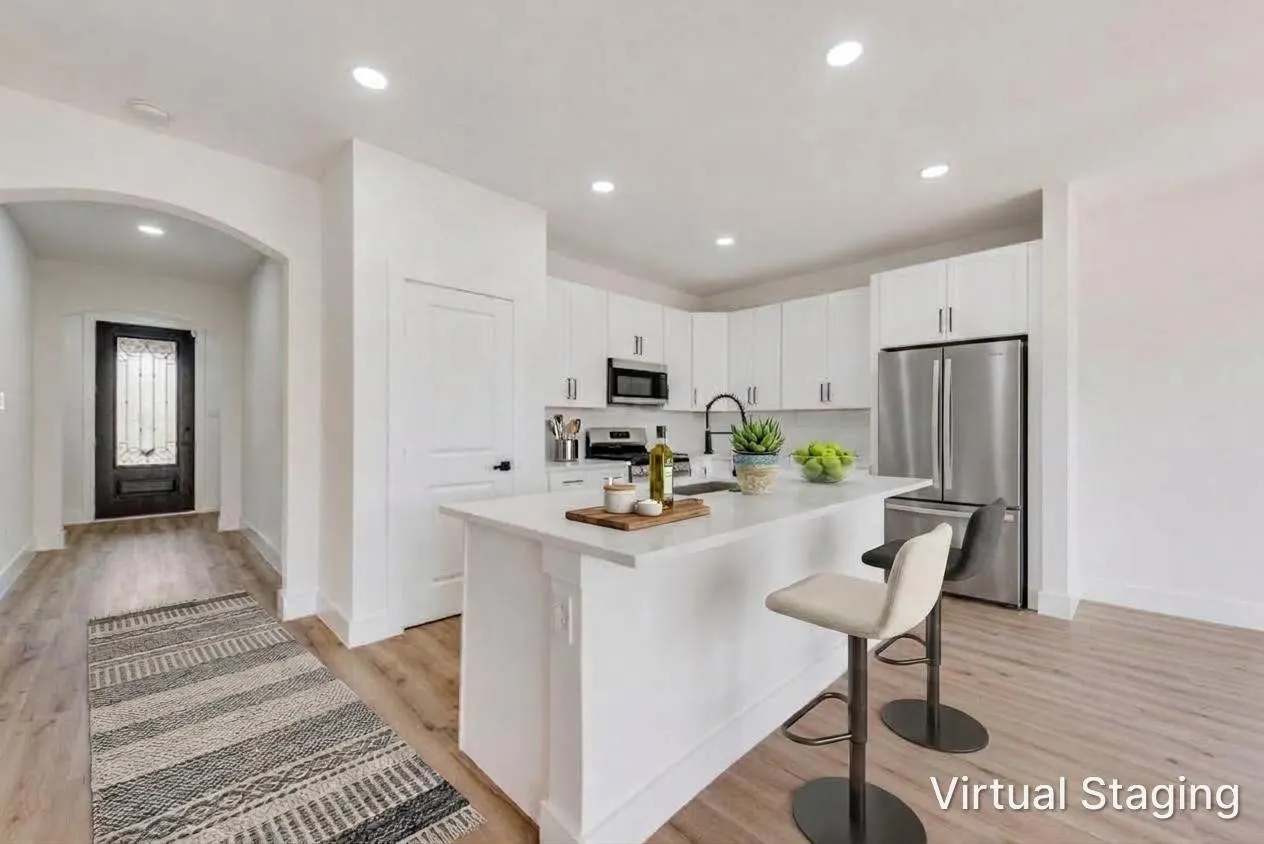 Kitchen featuring white cabinetry, stainless steel appliances, an island with countertop seating, and wood-finish flooring