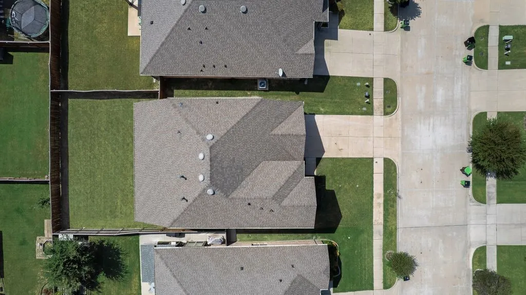 Gabled roofline, fenced backyard, concrete driveway, concrete sidewalks, and street access