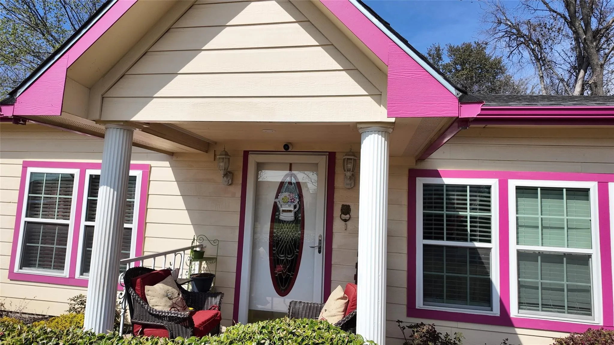 Entryway with fluted columns and a decorative glass front door