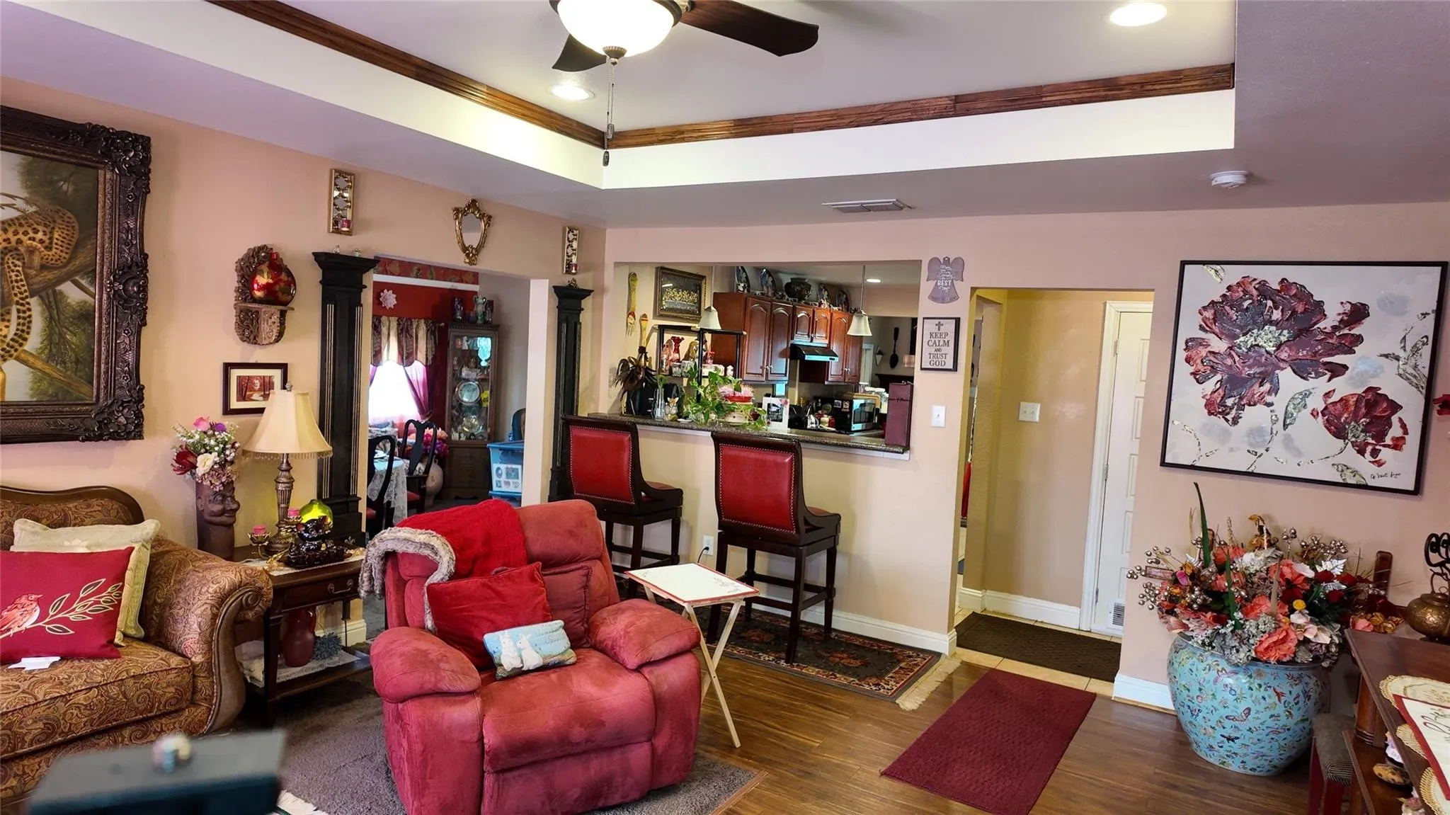 Tray ceiling with wood-finish accents, recessed lighting, and a ceiling fan