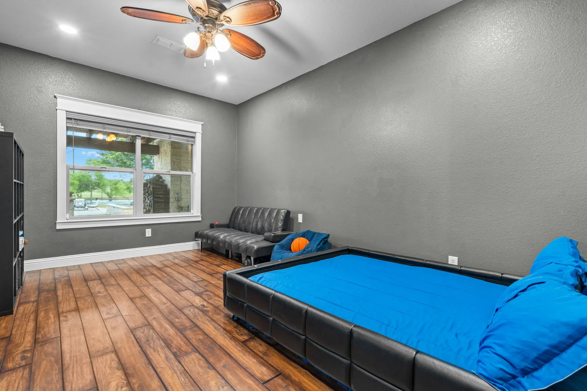 Recessed lighting, wood-finish flooring, ceiling fan, and a large window with white trim