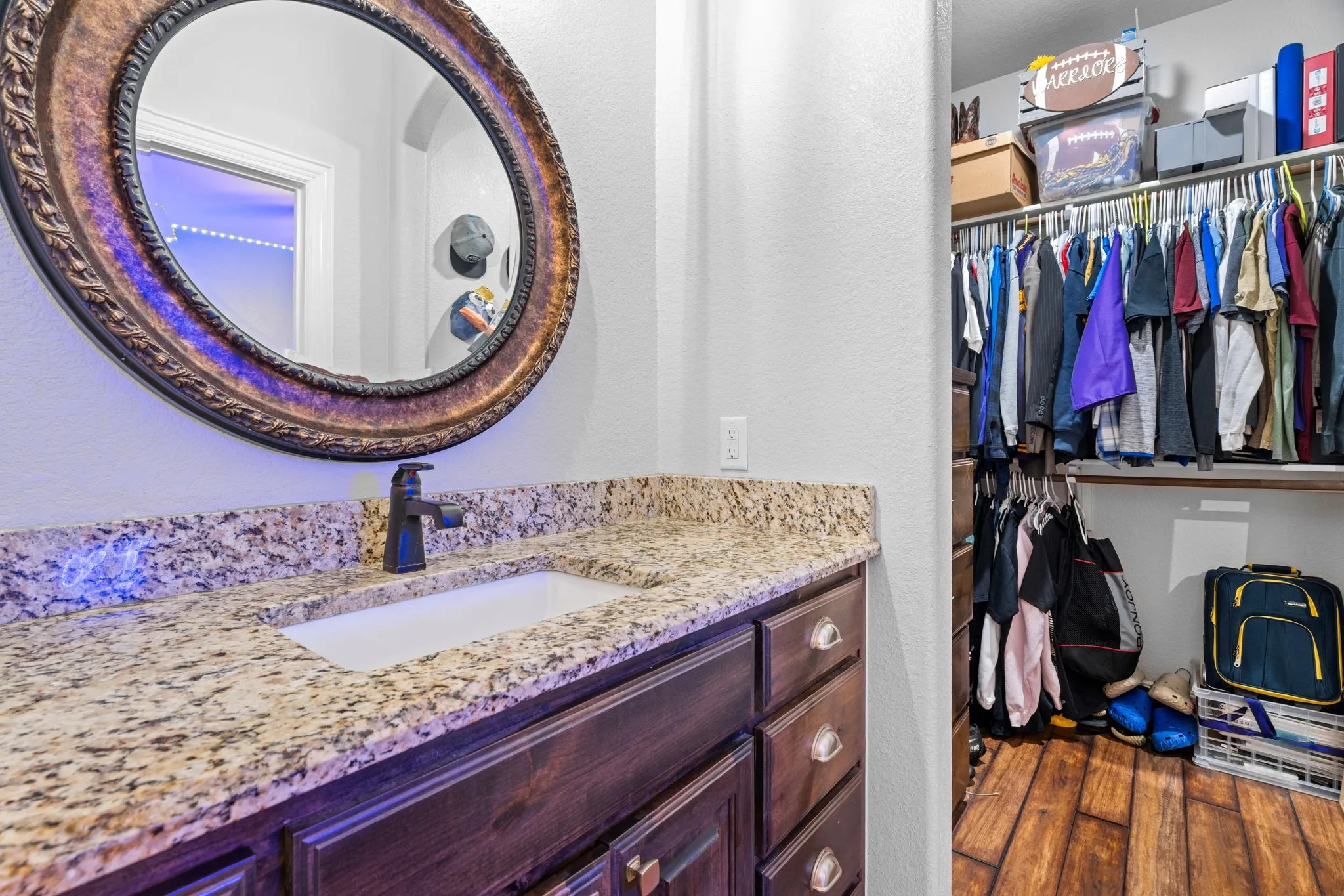 Vanity with a granite countertop, undermount sink, and dark wood-finish cabinetry