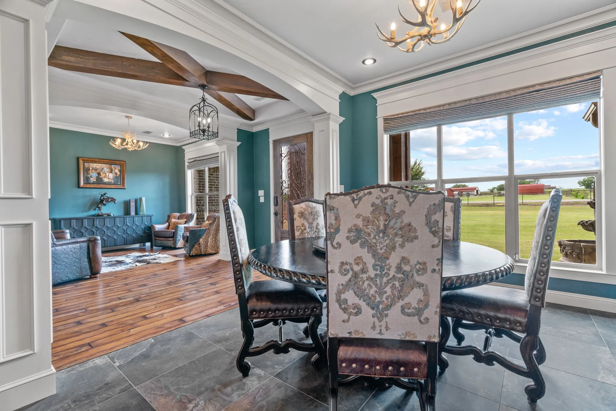 Arched entryway with wood beams, large window with outdoor expanse, tile flooring, wood-finish flooring, and crown molding