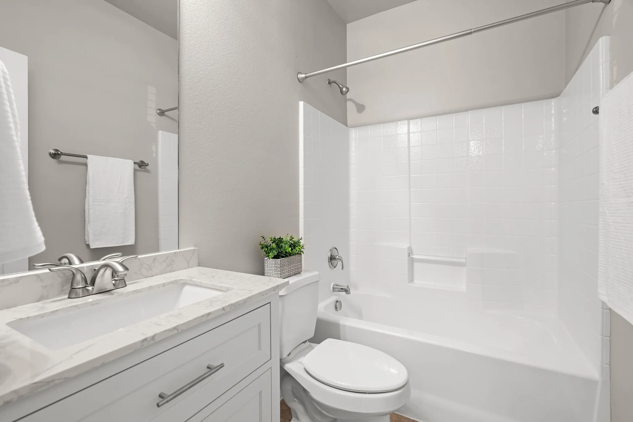 White vanity with cabinet storage, integrated sink, and brushed nickel hardware