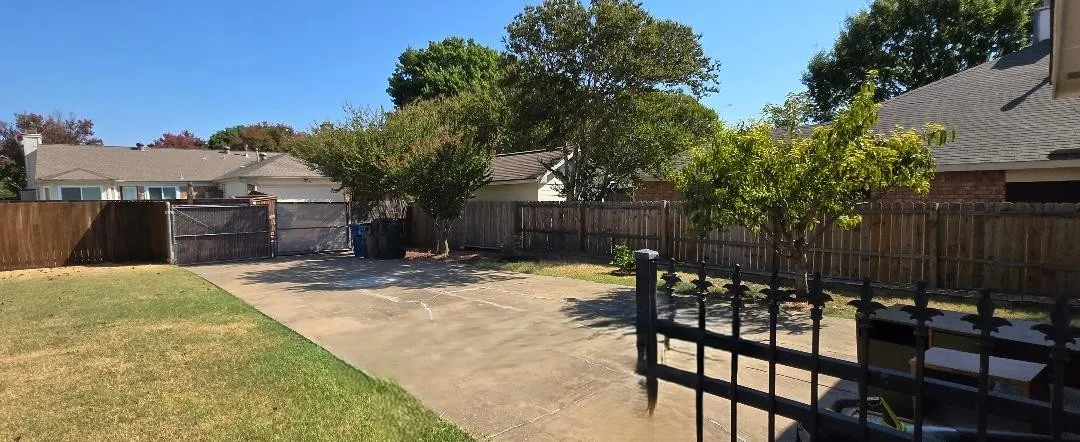 Expansive concrete pad, mature trees, and privacy fencing
