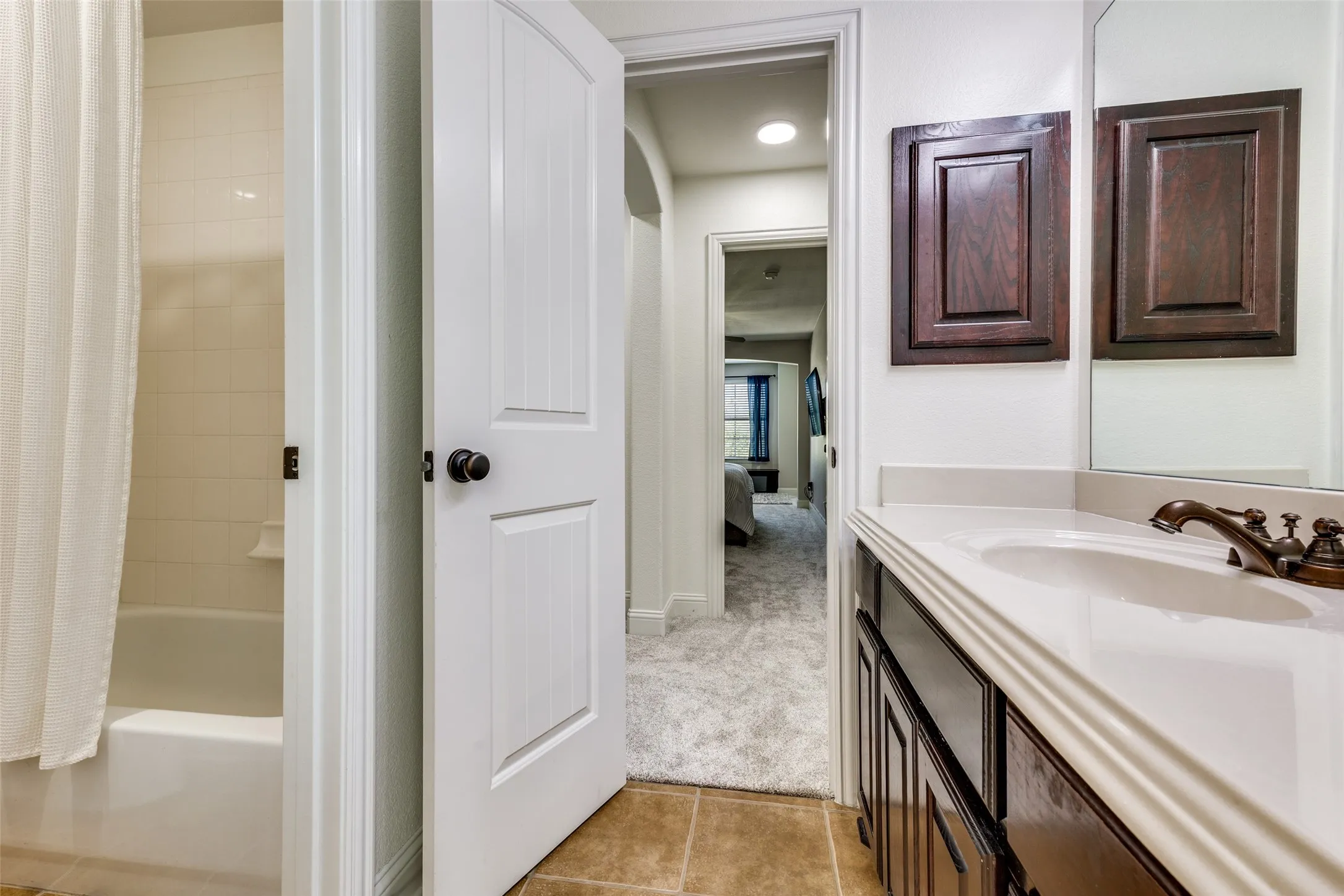 Bathroom with a white vanity countertop, white undermount sink, and bronze-finish faucet