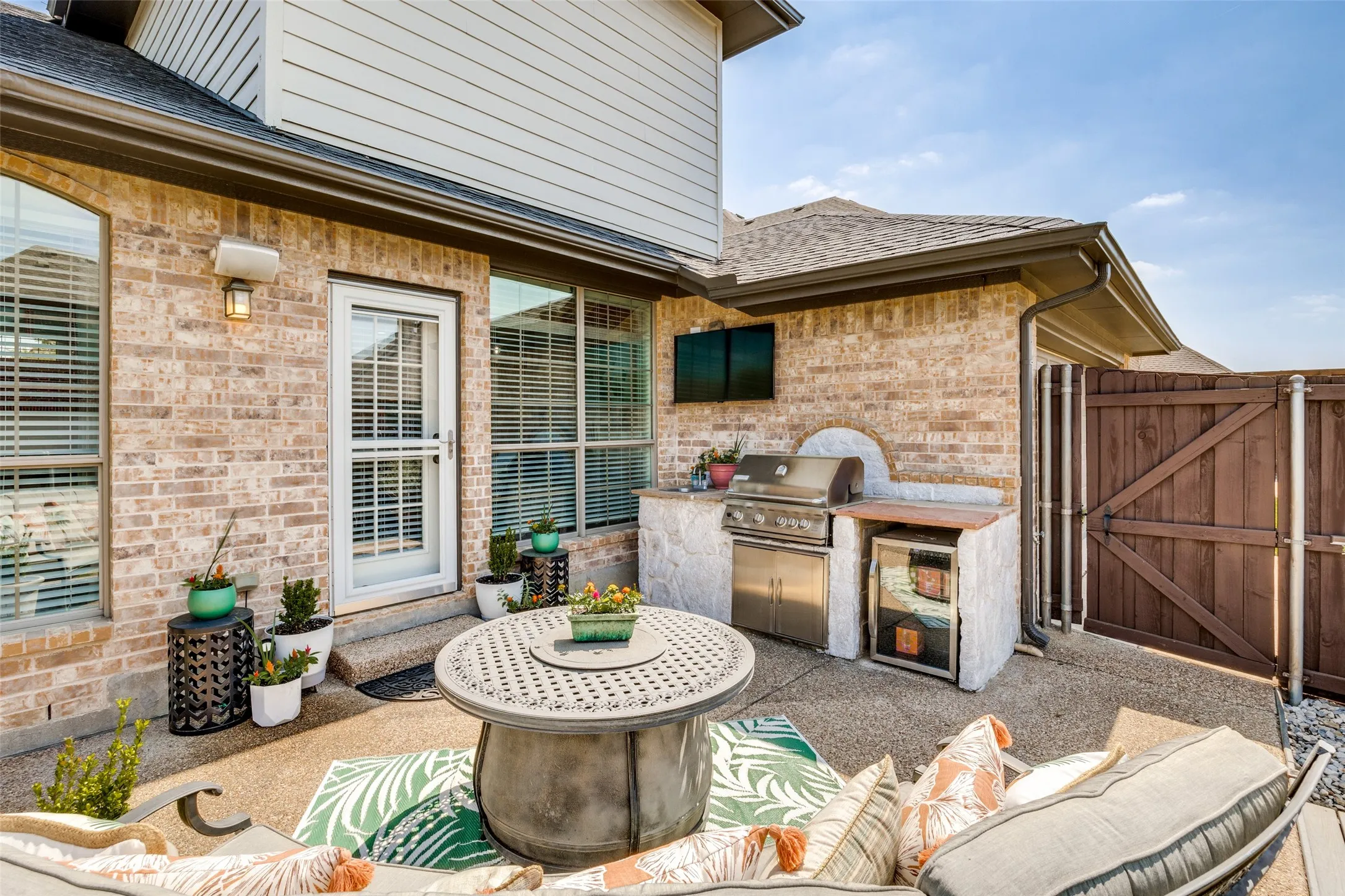 Outdoor kitchen featuring a built-in grill and beverage cooler