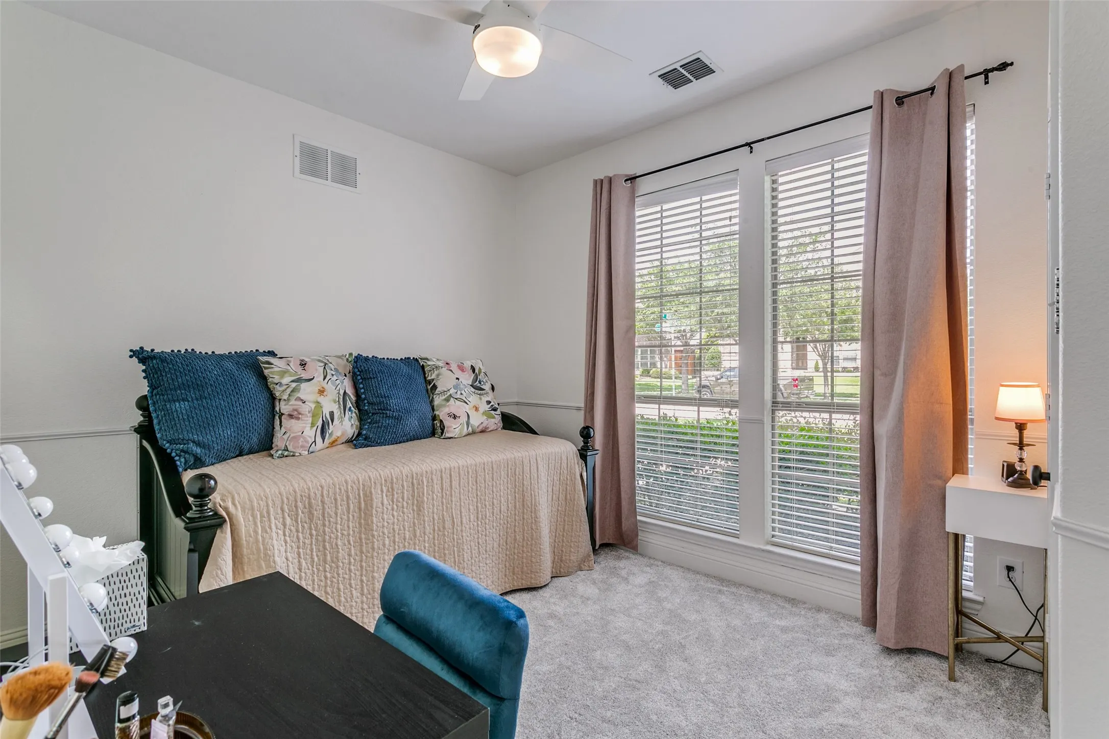 Carpeted room featuring dual windows with blinds, a ceiling fan, and crown molding