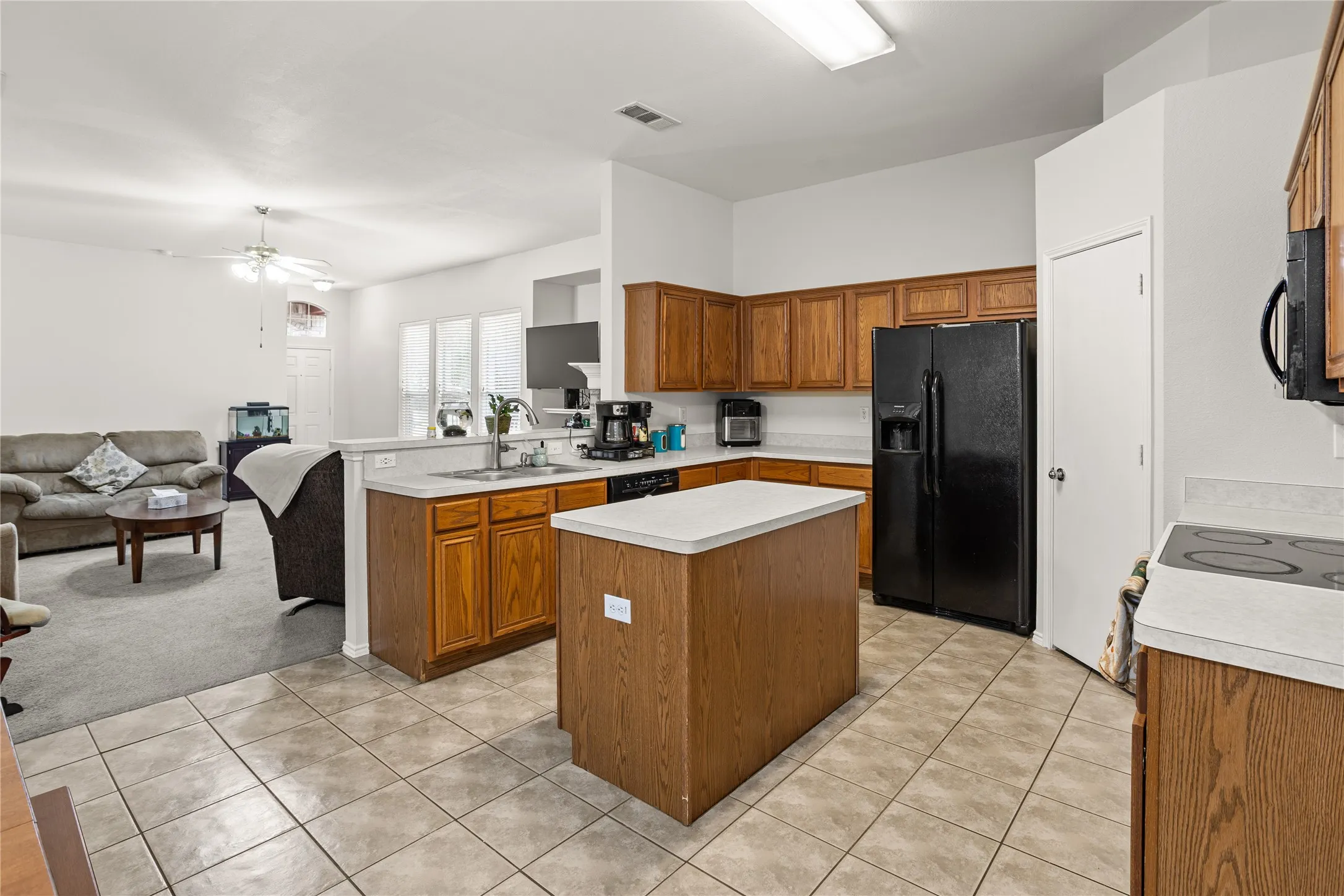 Kitchen featuring wood-finish cabinetry, tile flooring, and a central island