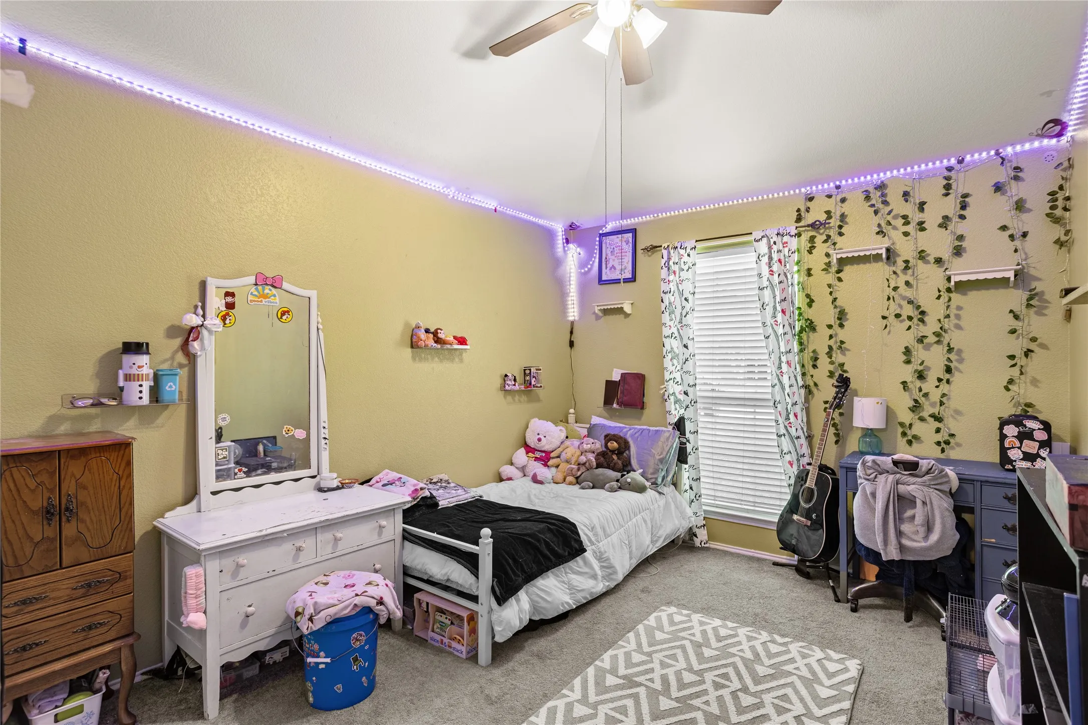 Carpeted flooring with a ceiling fan and window with blinds