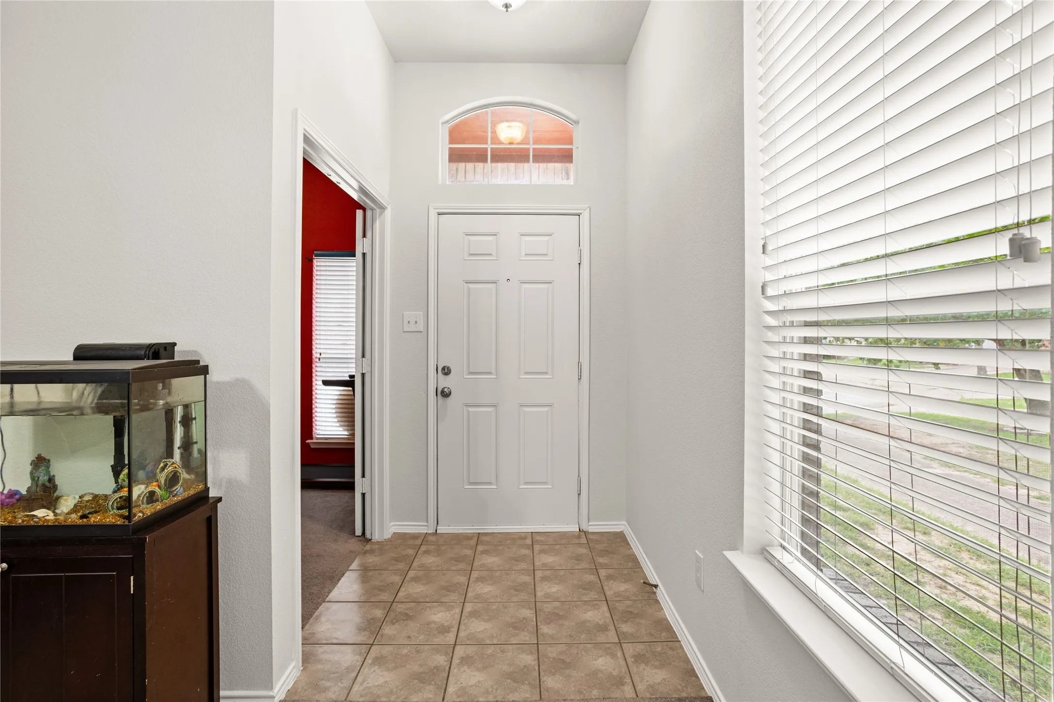Entryway featuring tile flooring, a paneled front door, and an arched transom window