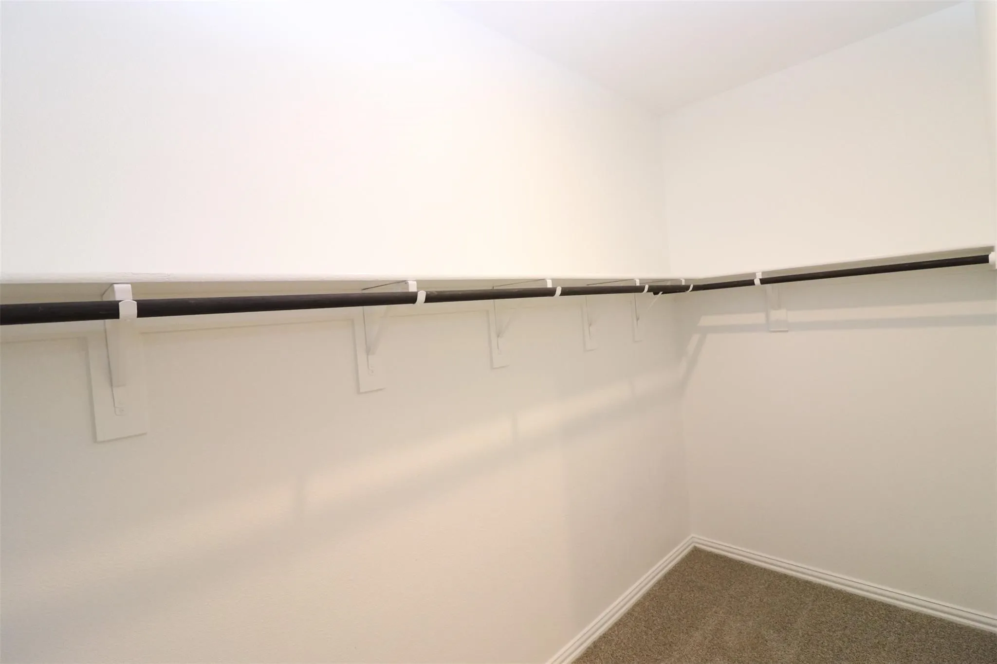 Corner closet with a single hanging rod and upper shelf