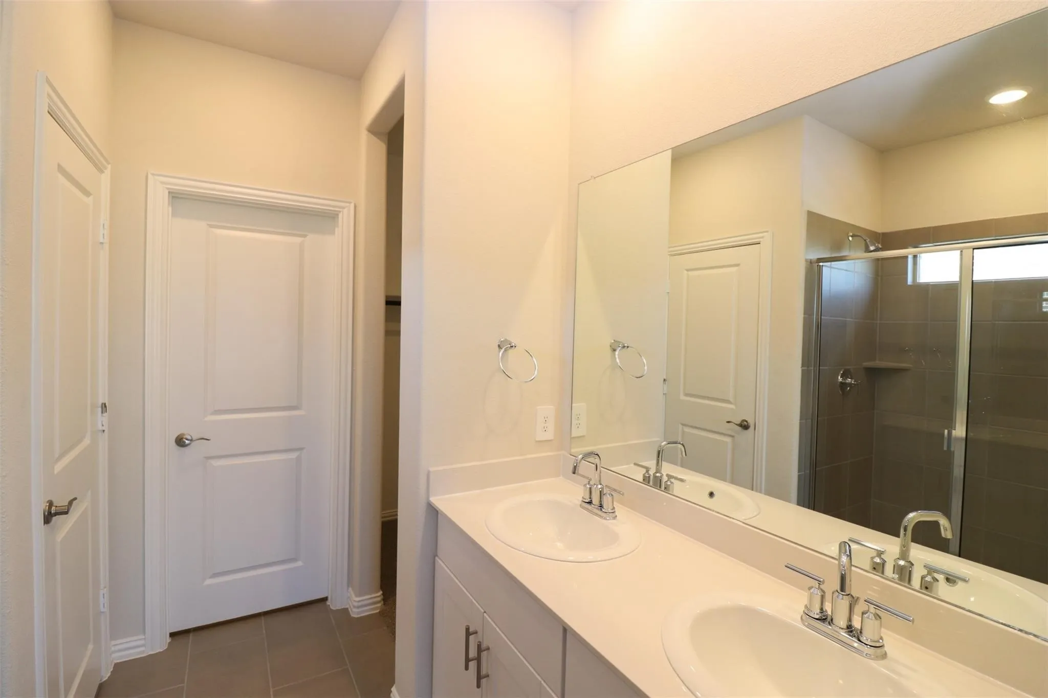 Dual vanity with integrated sinks, chrome fixtures, and a spacious framed mirror
