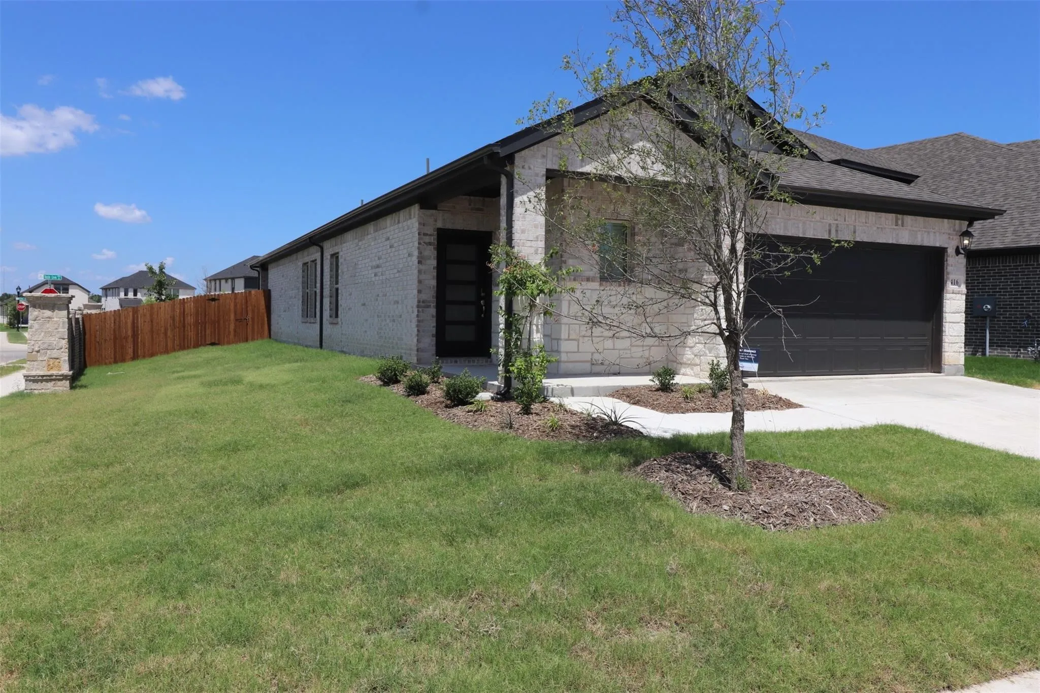 Stone exterior with dark trim and a dark garage door