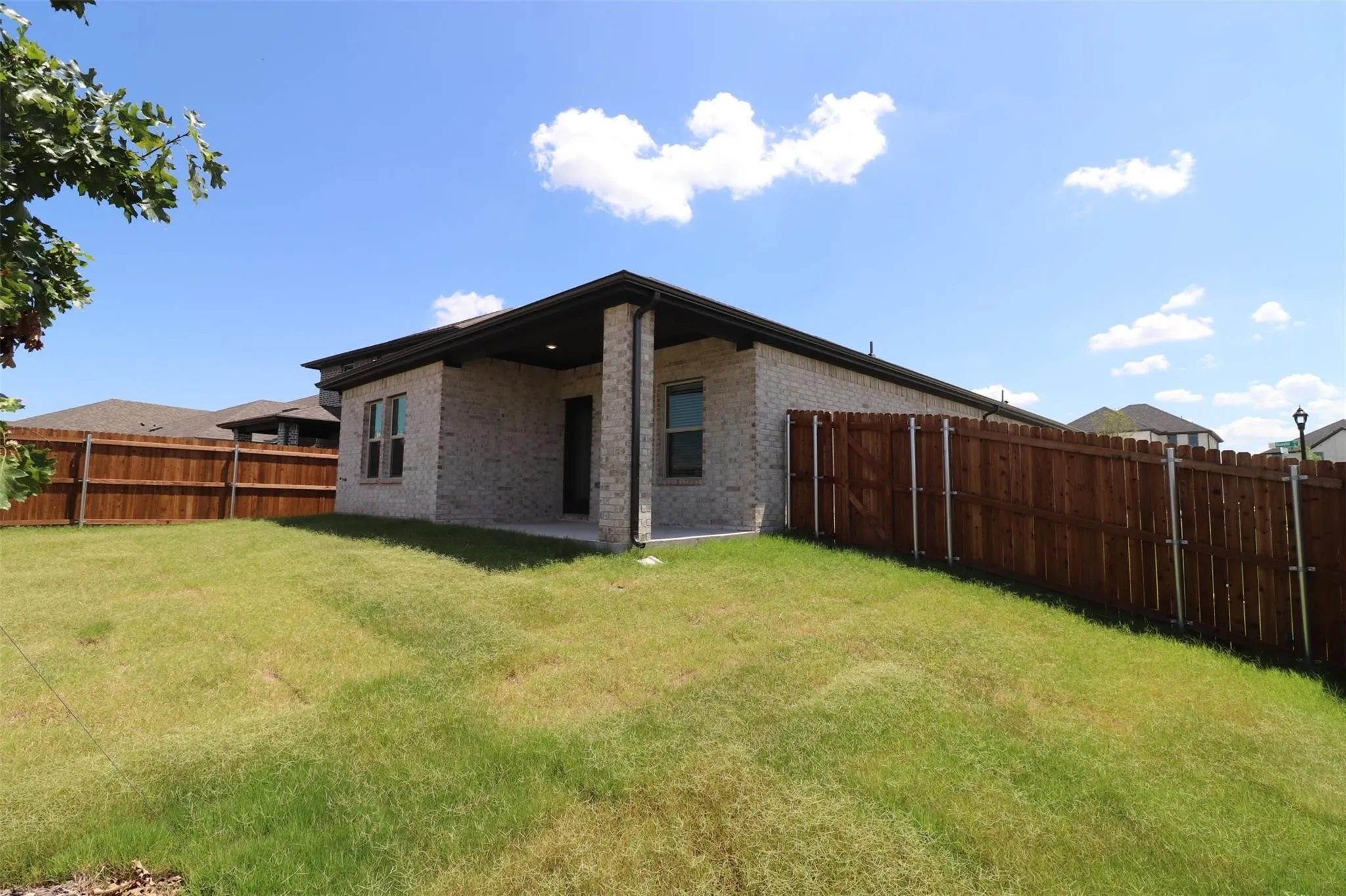 Expansive backyard featuring a wood privacy fence and a covered patio
