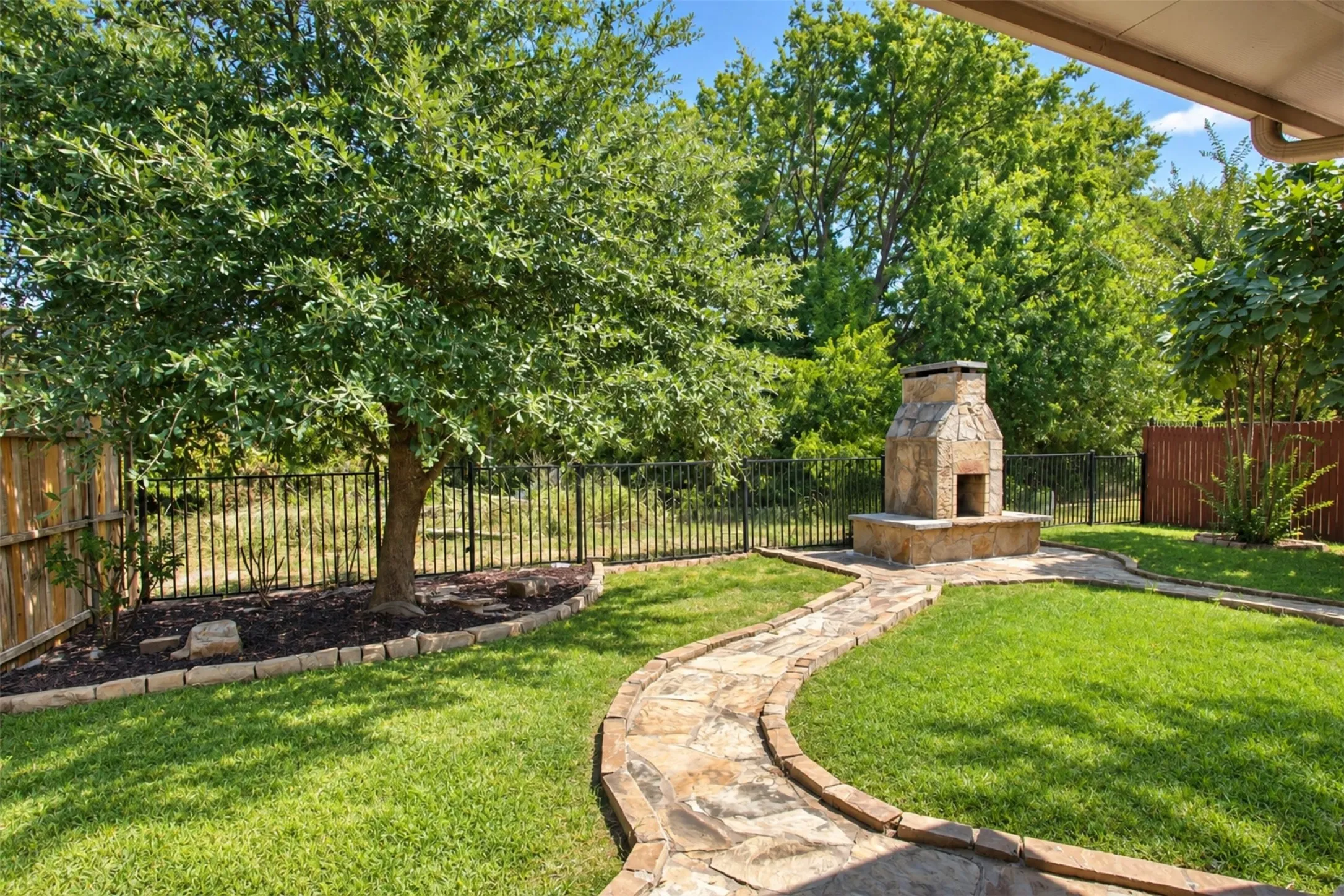 Expansive yard with lush green area behind