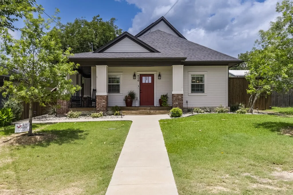 Charming cottage-style home featuring a welcoming front facade with brick and siding exterior, gabled roofline, and a covered front porch