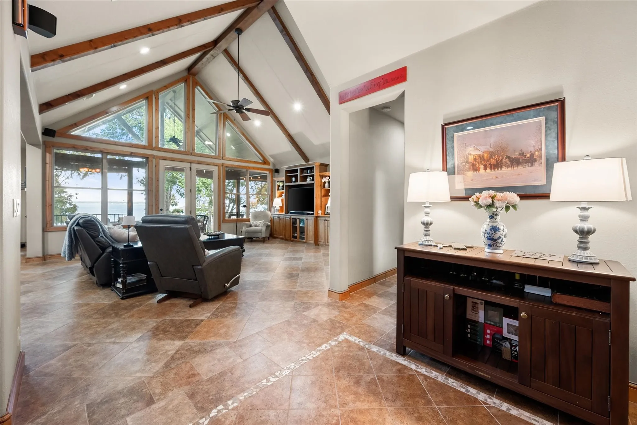 Dramatic cathedral ceilings, exposed wood accents, large windows, and an open layout define the impressive main living area.
