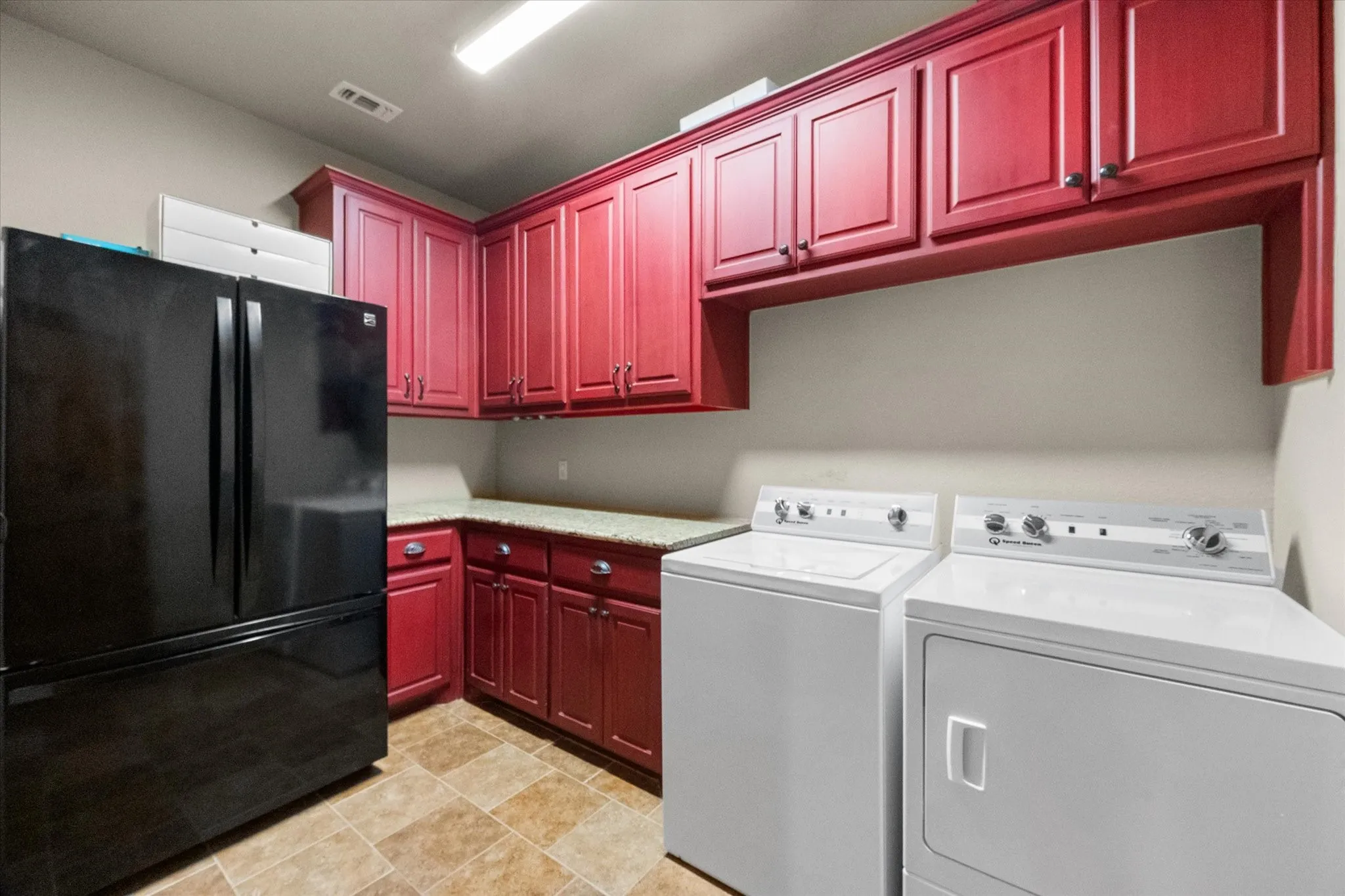 Separate utility room provides full-size laundry space, abundant cabinetry, and additional appliance and household storage.