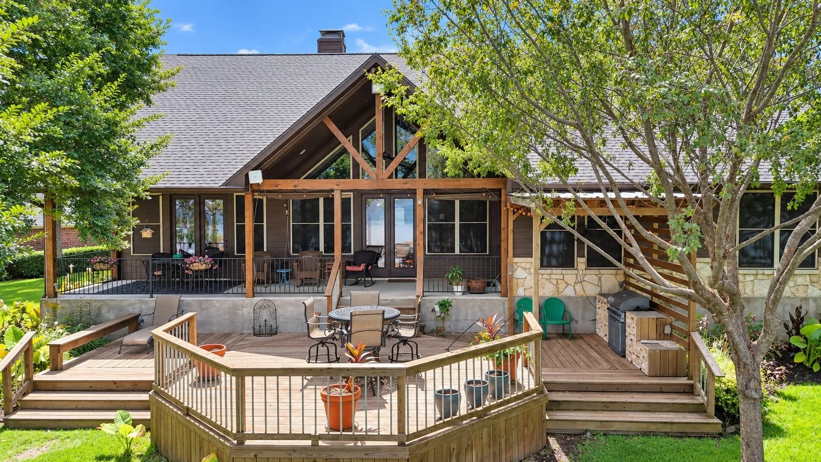 Spacious multi-level deck extends the home's living space outdoors with room for dining and gathering beneath the trees.