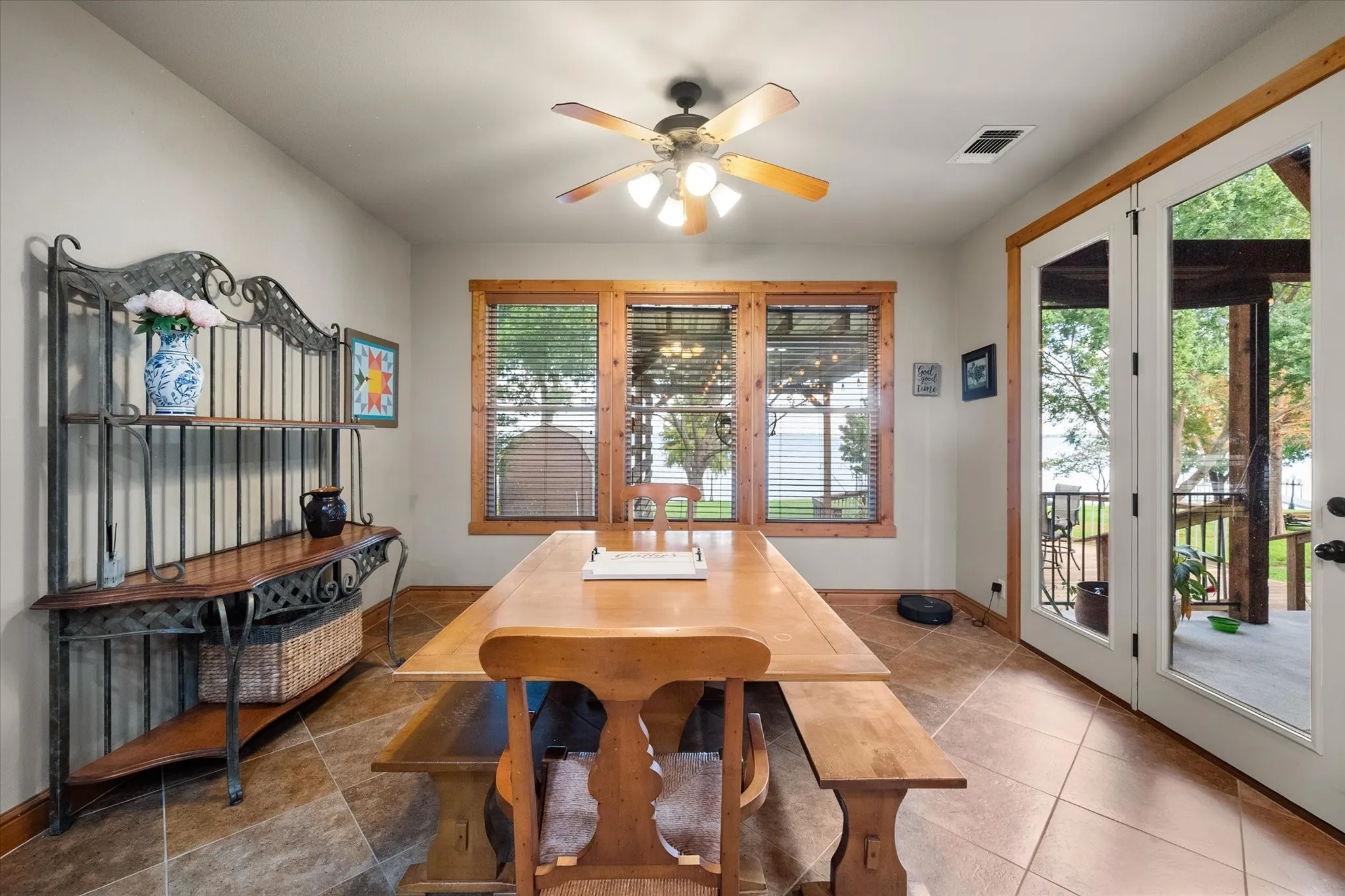 Casual dining area offers abundant natural light, tile flooring, and convenient access to the home's outdoor living spaces.
