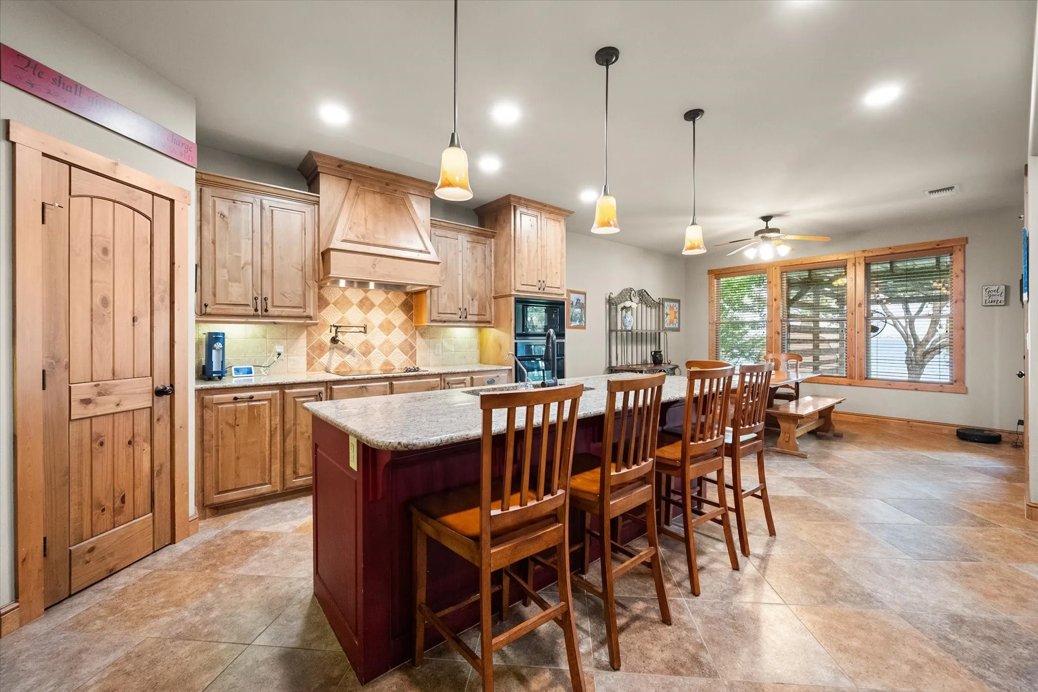 Warm wood cabinetry, pendant lighting, generous counter space, and an oversized island make this kitchen ideal for everyday meals and entertaining.