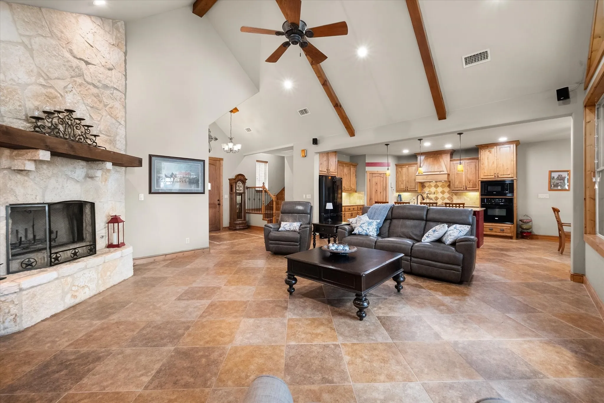 Wide-angle view showcases the home's open floor plan, stone fireplace, vaulted architecture, and spacious main-level entertaining areas.