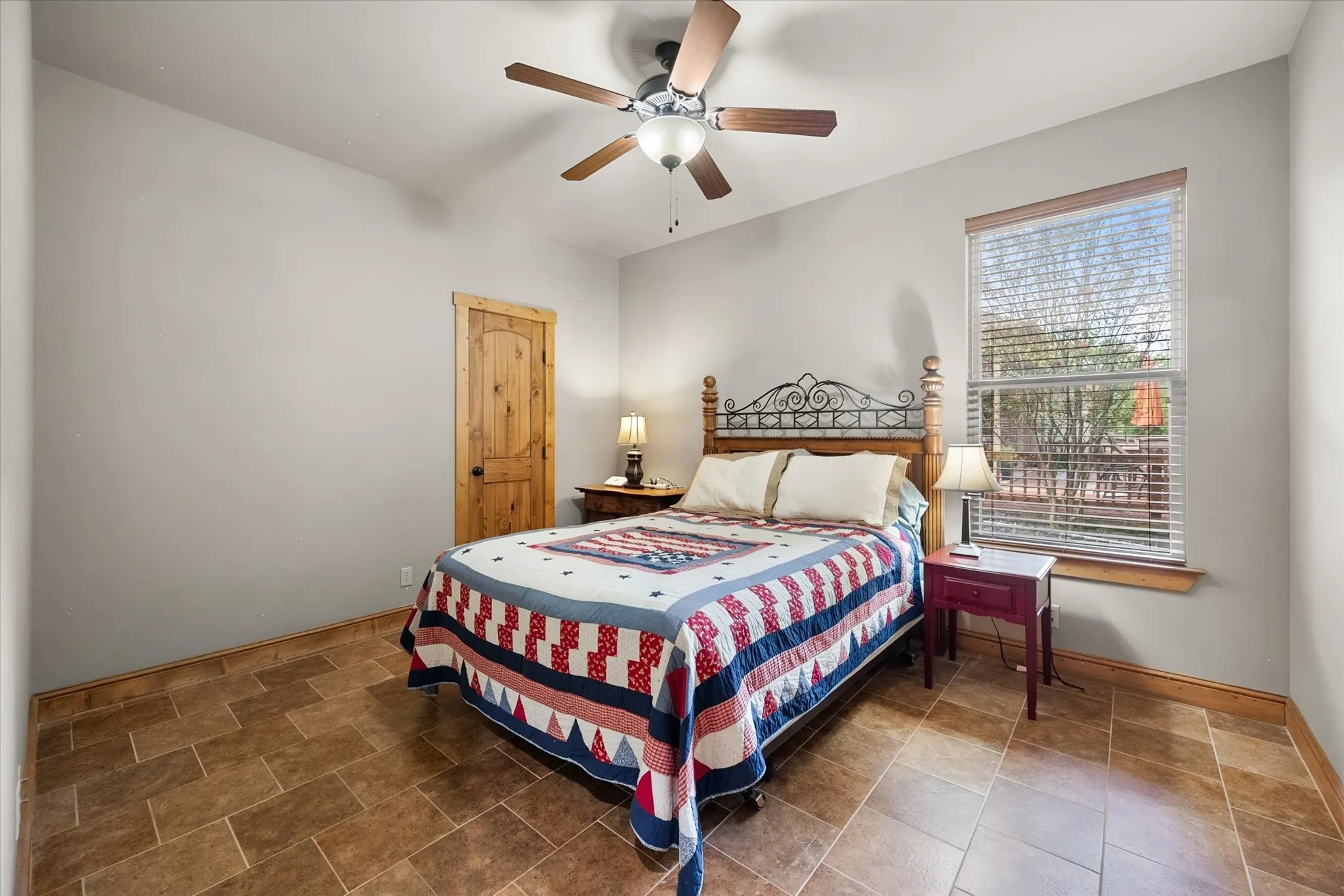 Comfortable guest bedroom features a ceiling fan, natural light, neutral finishes, and space for overnight family and friends.