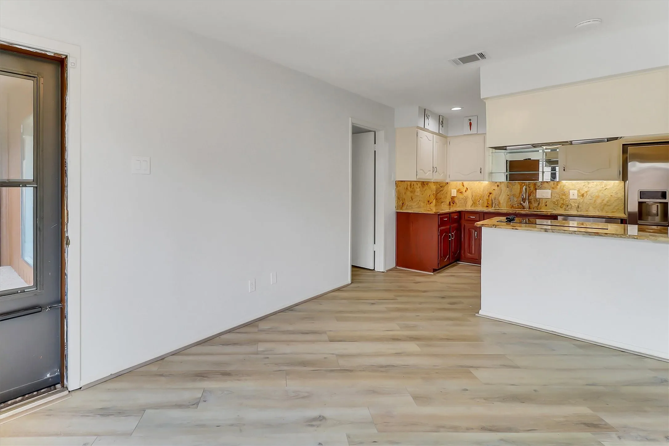 Easy access to private courtyard with towering tree and secure iron gate