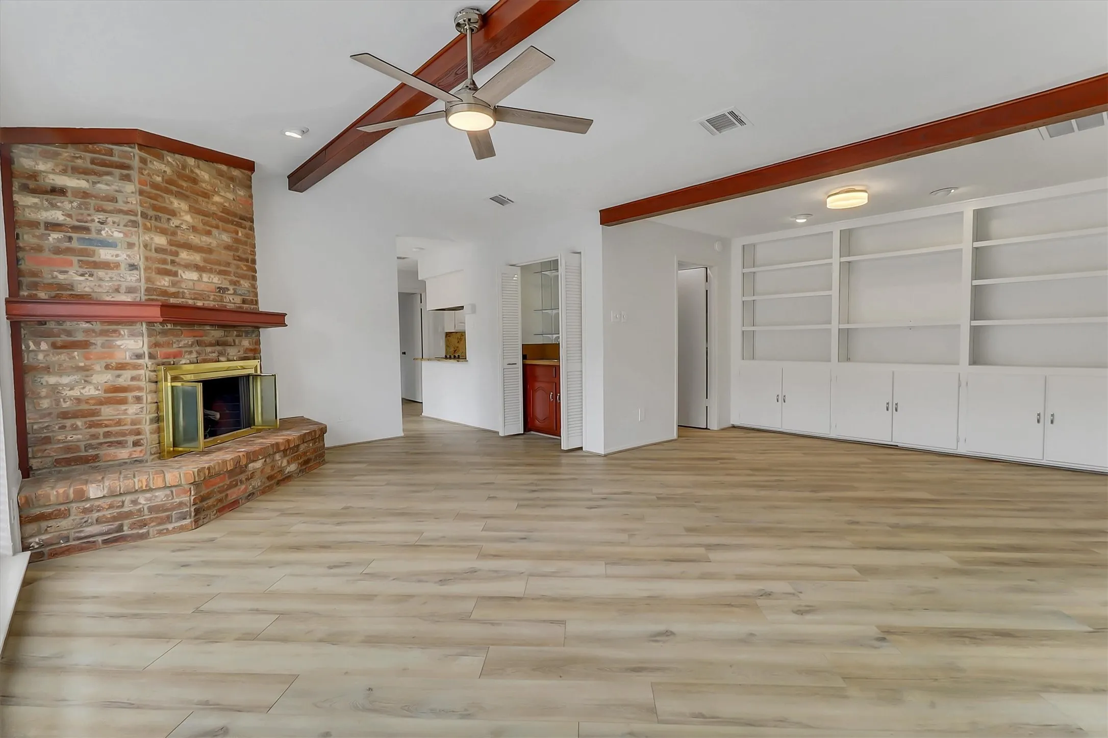 Large living room with gas logs, wet bar, beamed ceilings and wood blinds